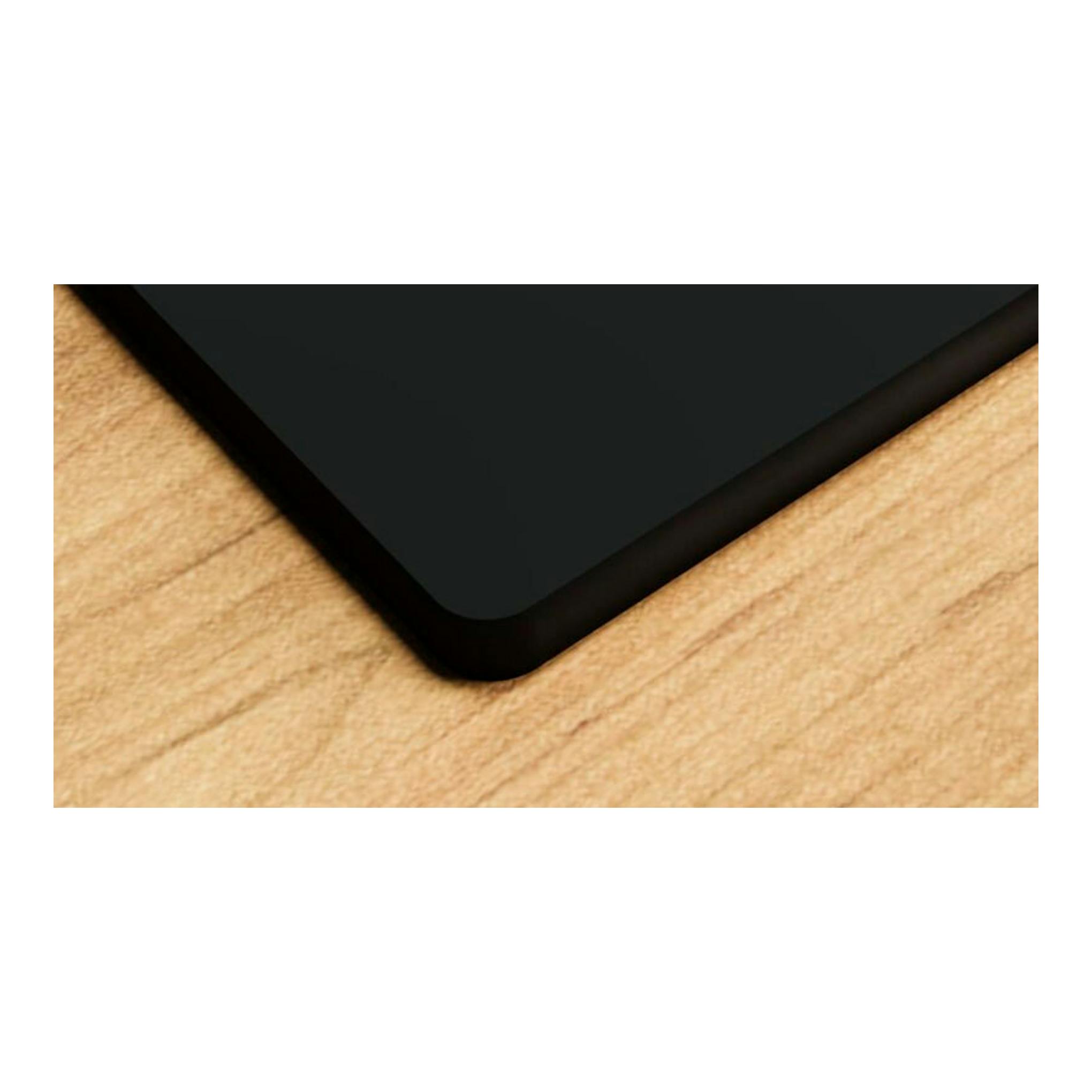 Placa de cristal Bosch PNC6B6K40 negra, vista en ángulo de la esquina sobre superficie de madera.