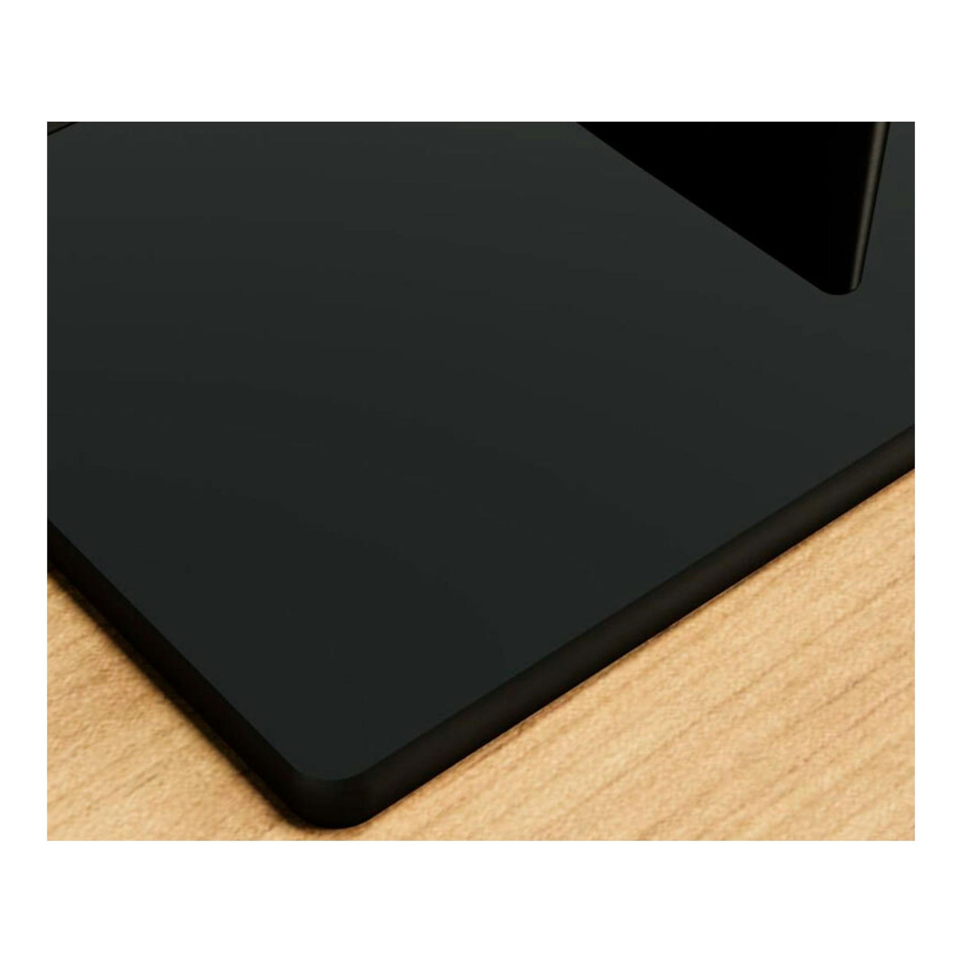 Placa Bosch PPH6A6I10 negra de cristal, vista en primer plano de una esquina sobre fondo de madera.