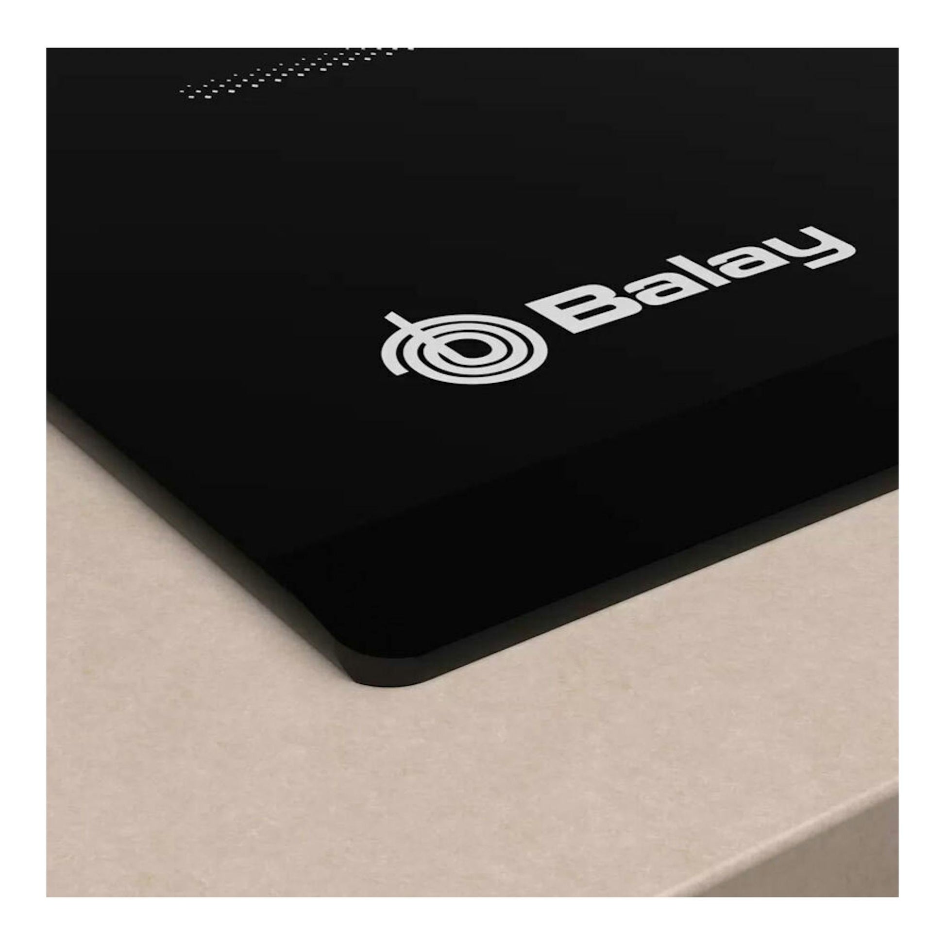 Placa de inducción Balay 3EB864FR negra, vista en ángulo sobre encimera beige.