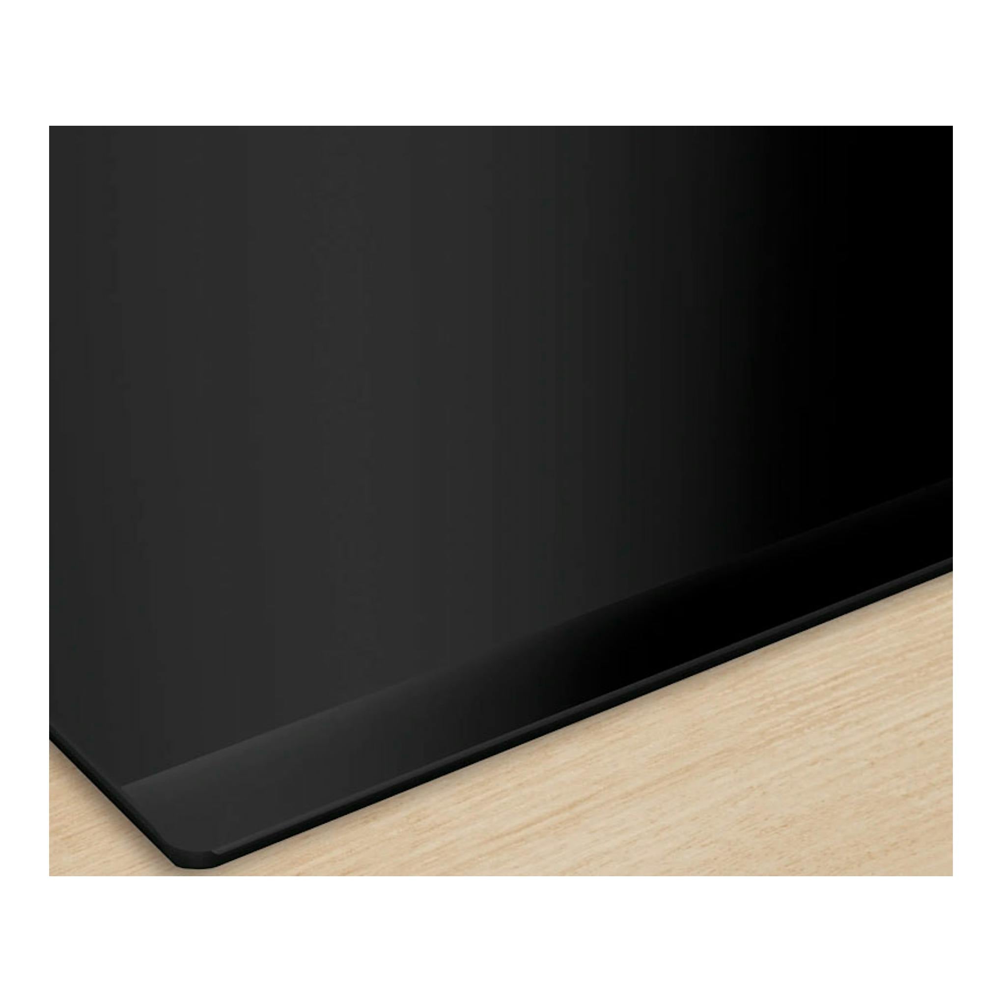 Placa de inducción Bosch PID631HC1E negra, vista parcial en ángulo sobre encimera de madera clara.