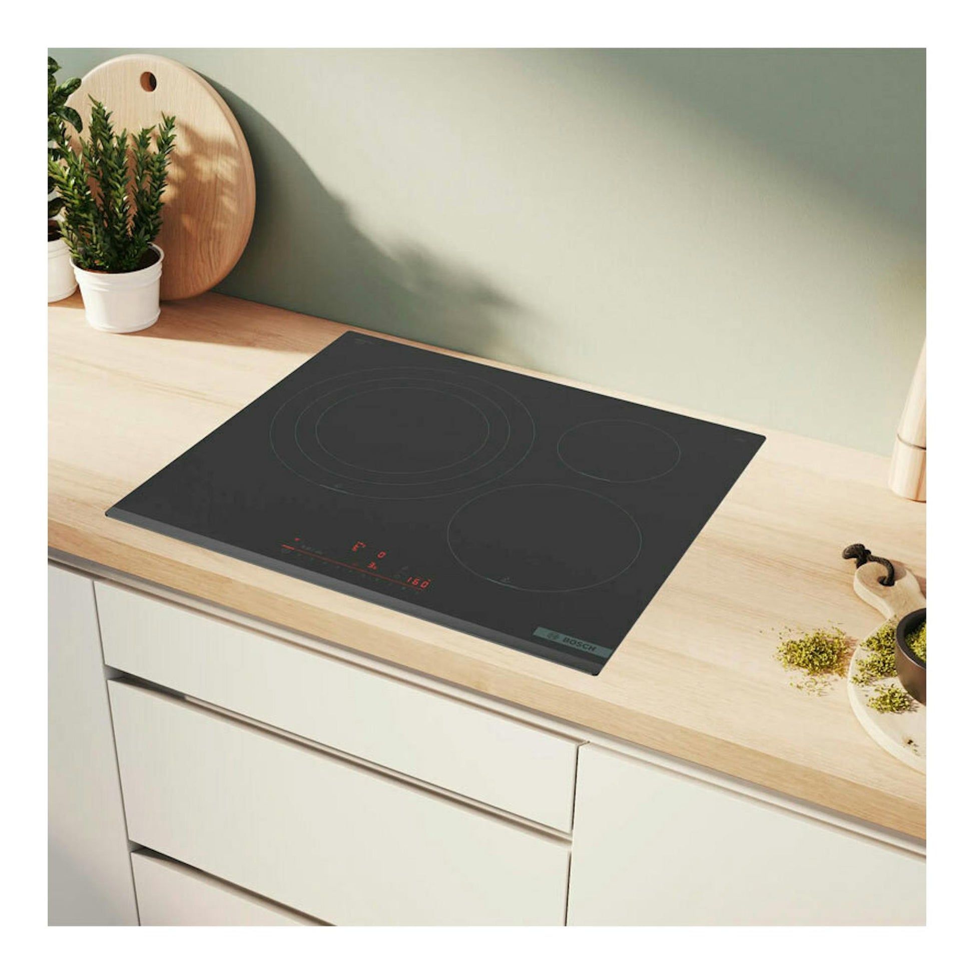 Placa de inducción Bosch PID631HC1E negra, vista en ángulo sobre encimera de madera clara.