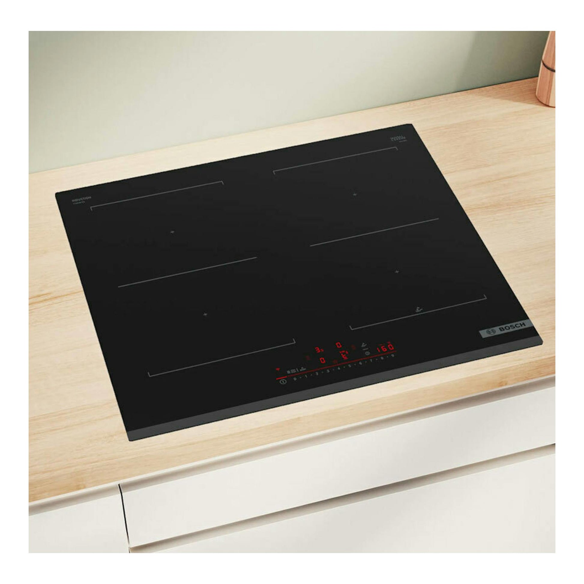 Placa de inducción Bosch PVQ631HC1E negra, vista en ángulo sobre encimera de madera, con panel táctil rojo.