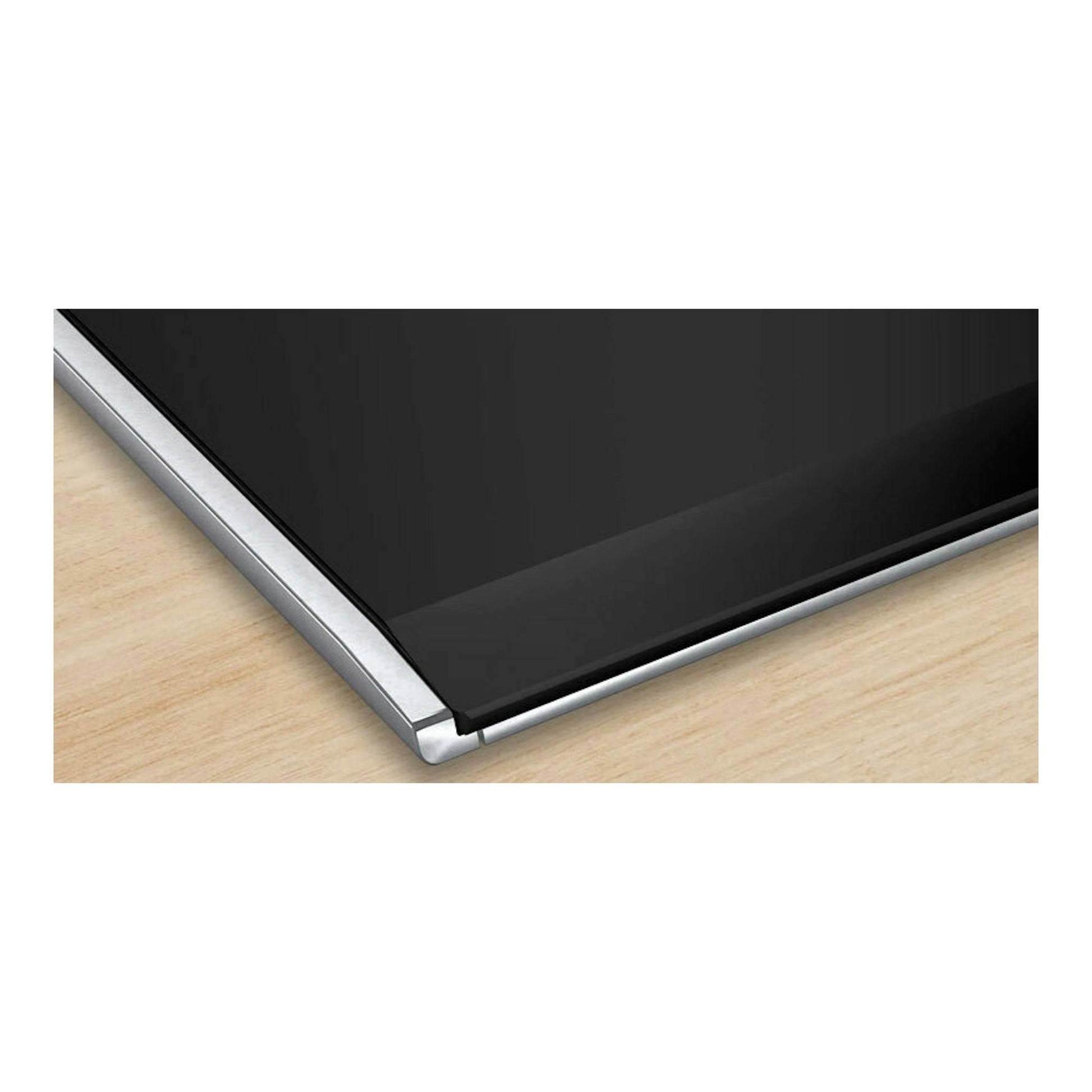 Placa de inducción Bosch PXV975DV1E negra, vista en ángulo con borde metálico sobre encimera de madera.