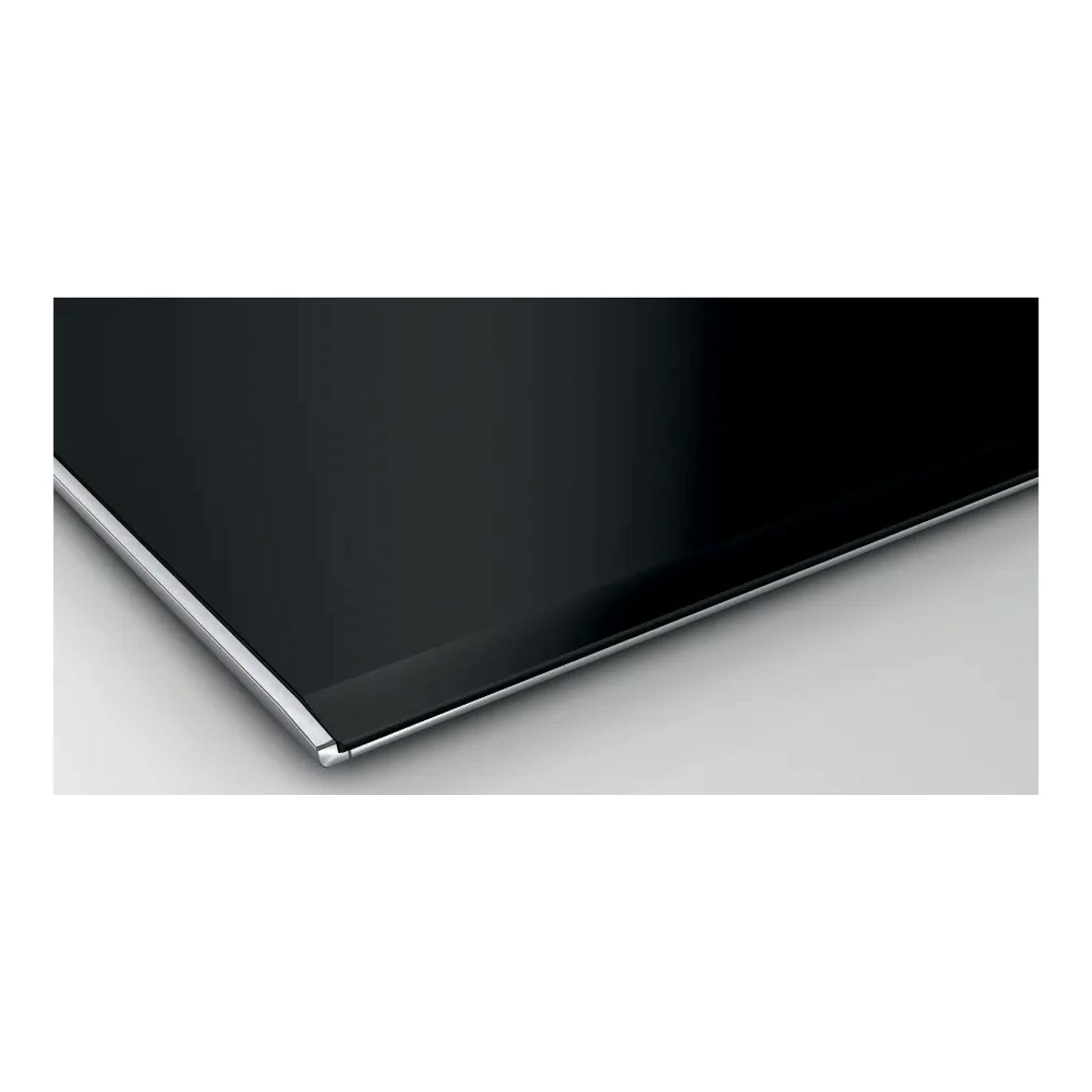 Bosch PXX875D57E, placa de inducción negra con borde metálico, vista en primer plano de una esquina.
