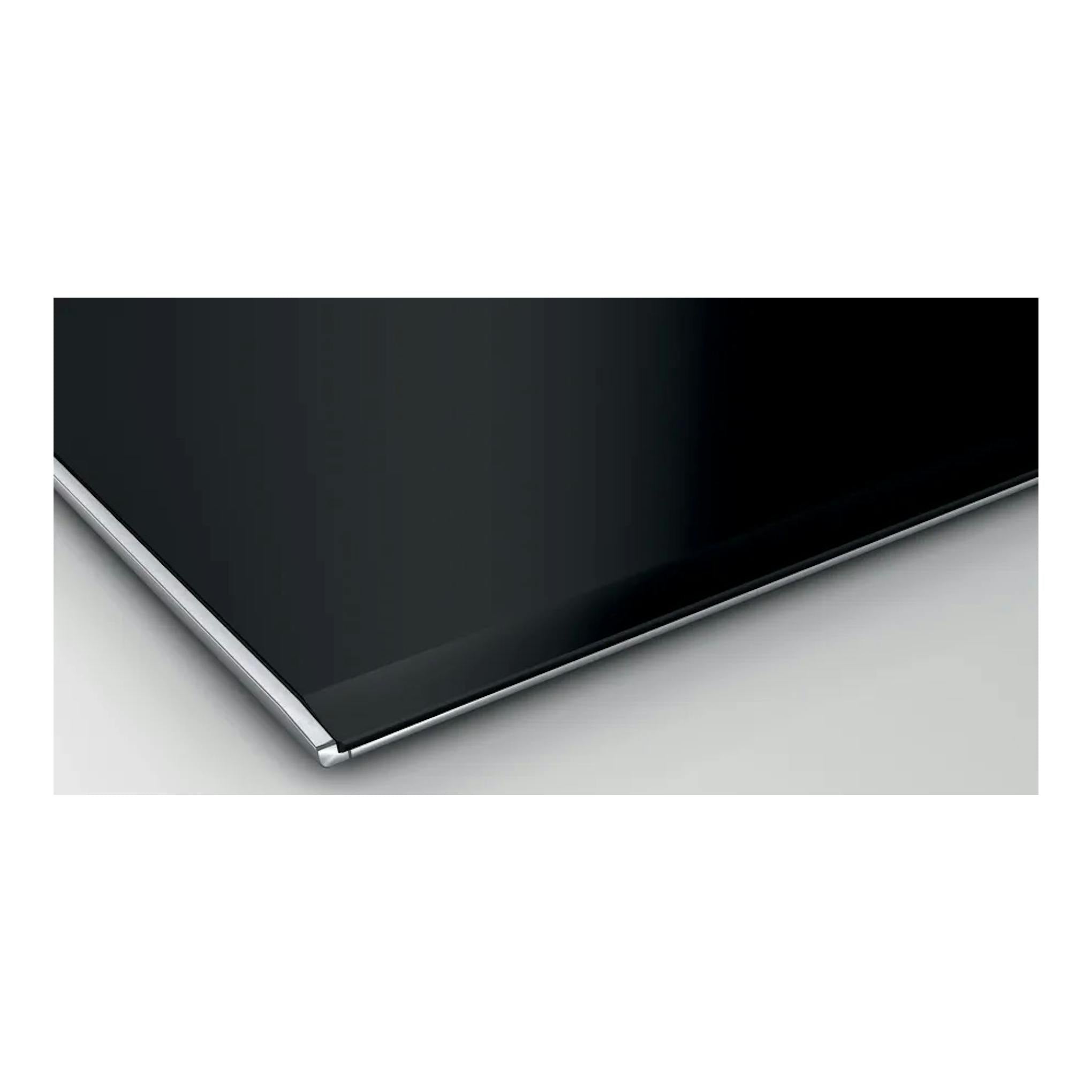 Bosch PXX875D57E, placa de inducción negra con borde metálico, vista en primer plano de una esquina.