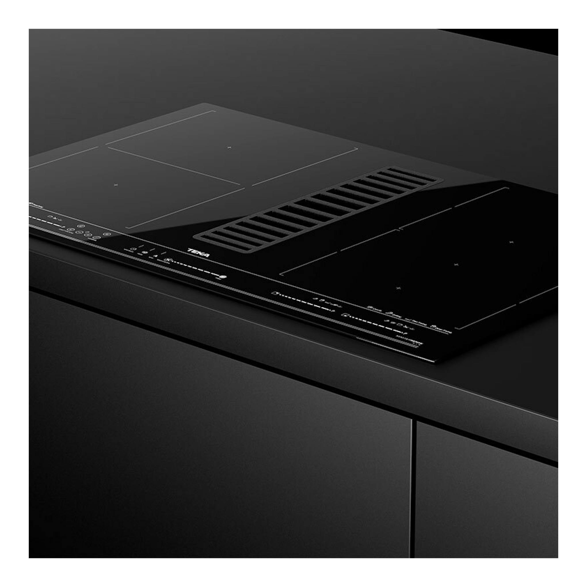 Placa de inducción negra Teka AFF87601MST con extractor central, vista en ángulo.