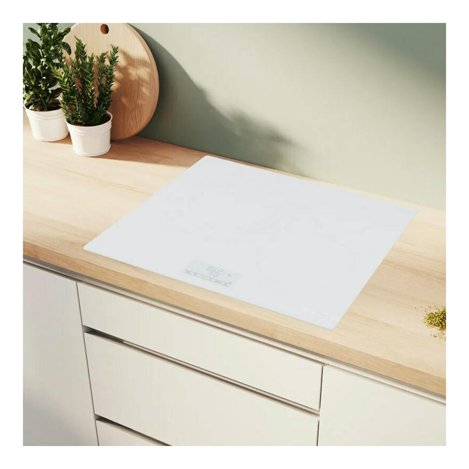 Placa de inducción Bosch PID612BB1E blanca, vista superior inclinada, integrada en encimera de madera.