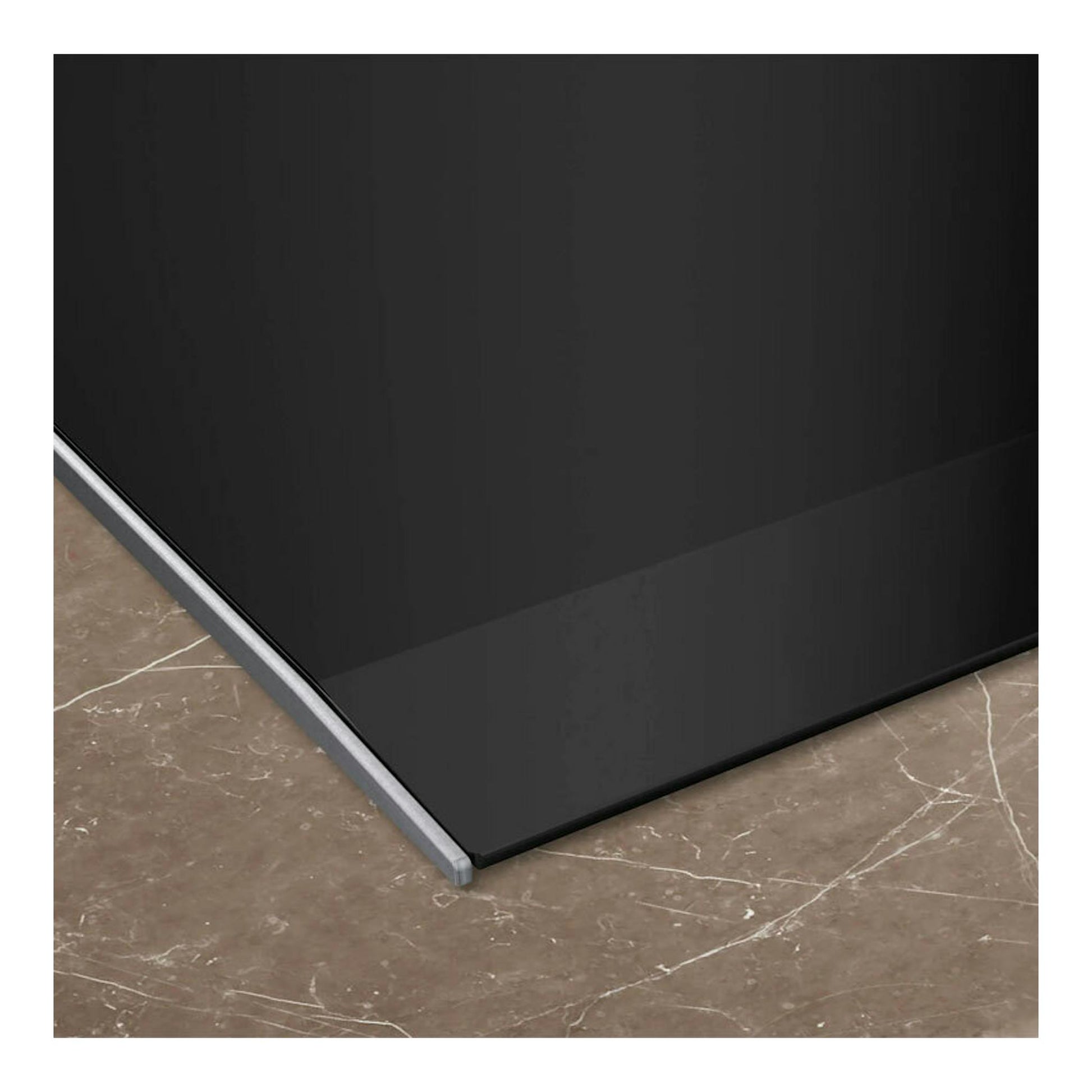 Primer plano de la esquina de una placa de inducción Siemens EH677HCC1E negra sobre encimera de mármol.