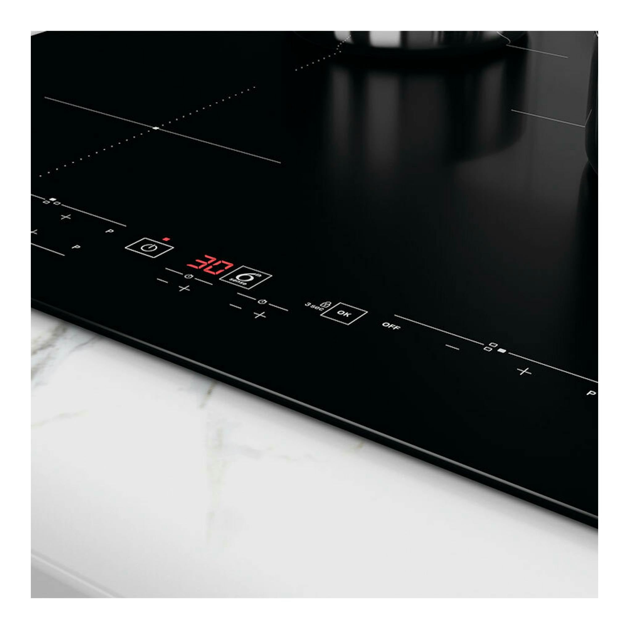 Placa de inducción Whirlpool WSB7560NE negra, vista en ángulo con panel táctil y display rojo.