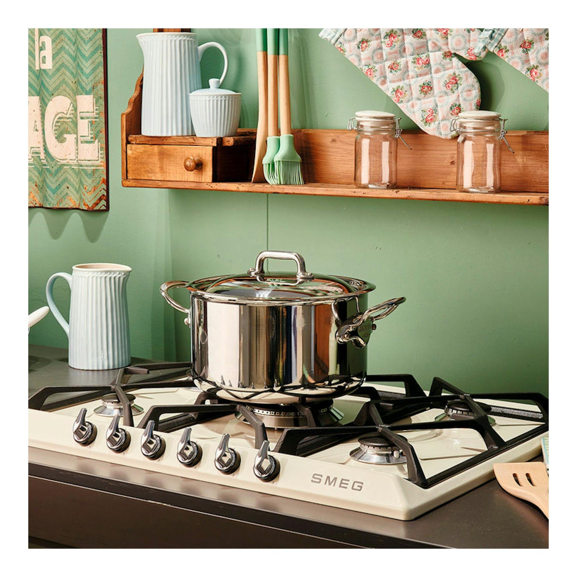 Placa de gas Smeg SR975PGH color crema, vista en ángulo con una olla de acero inoxidable sobre los quemadores.