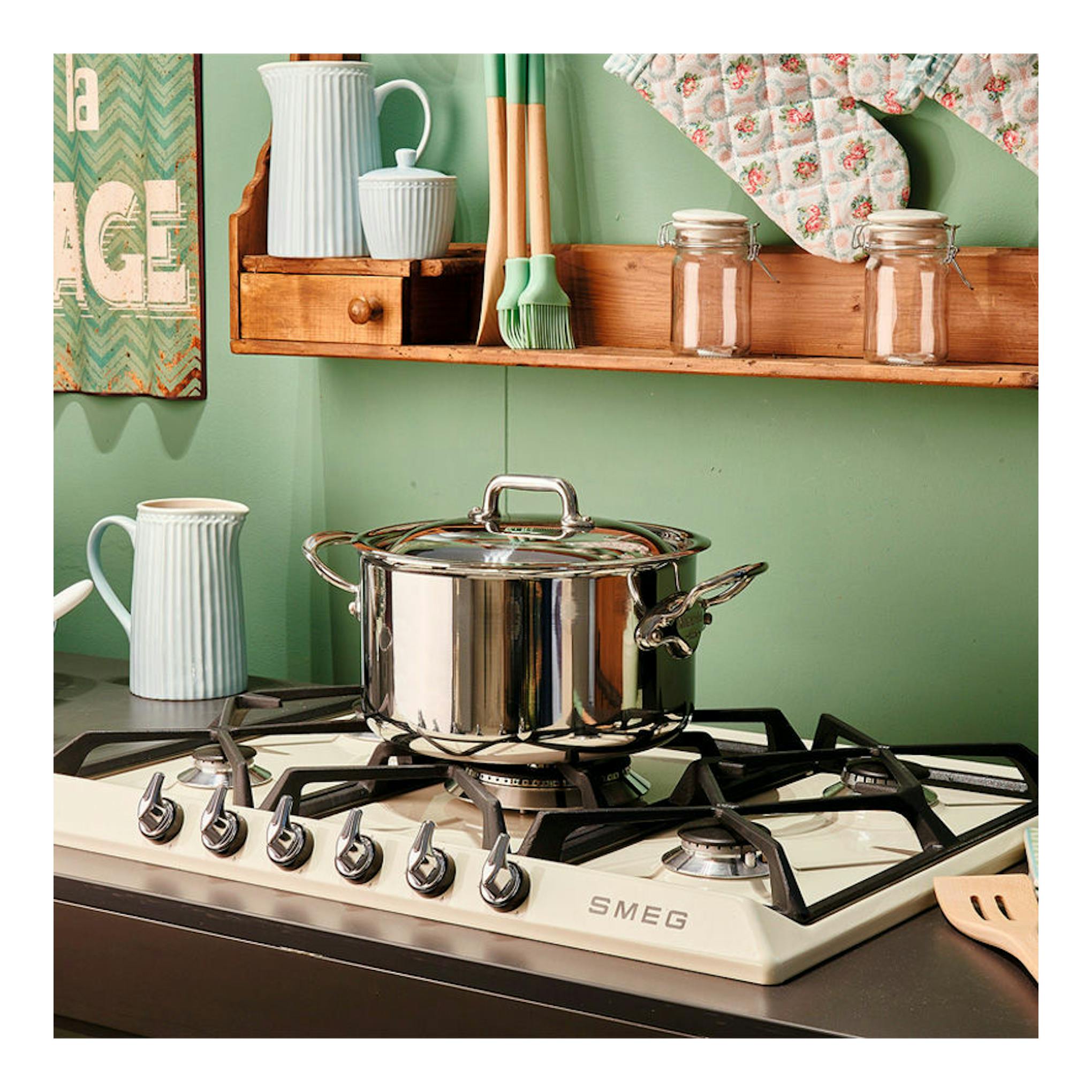 Placa de gas Smeg SR975PGH color crema, vista en ángulo con una olla de acero inoxidable sobre los quemadores.