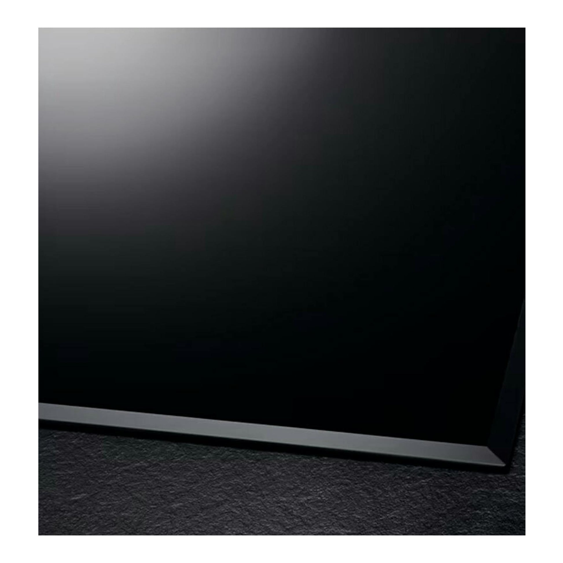 Placa de inducción AEG IKB63302FB negra, vista en ángulo de la esquina sobre fondo oscuro.