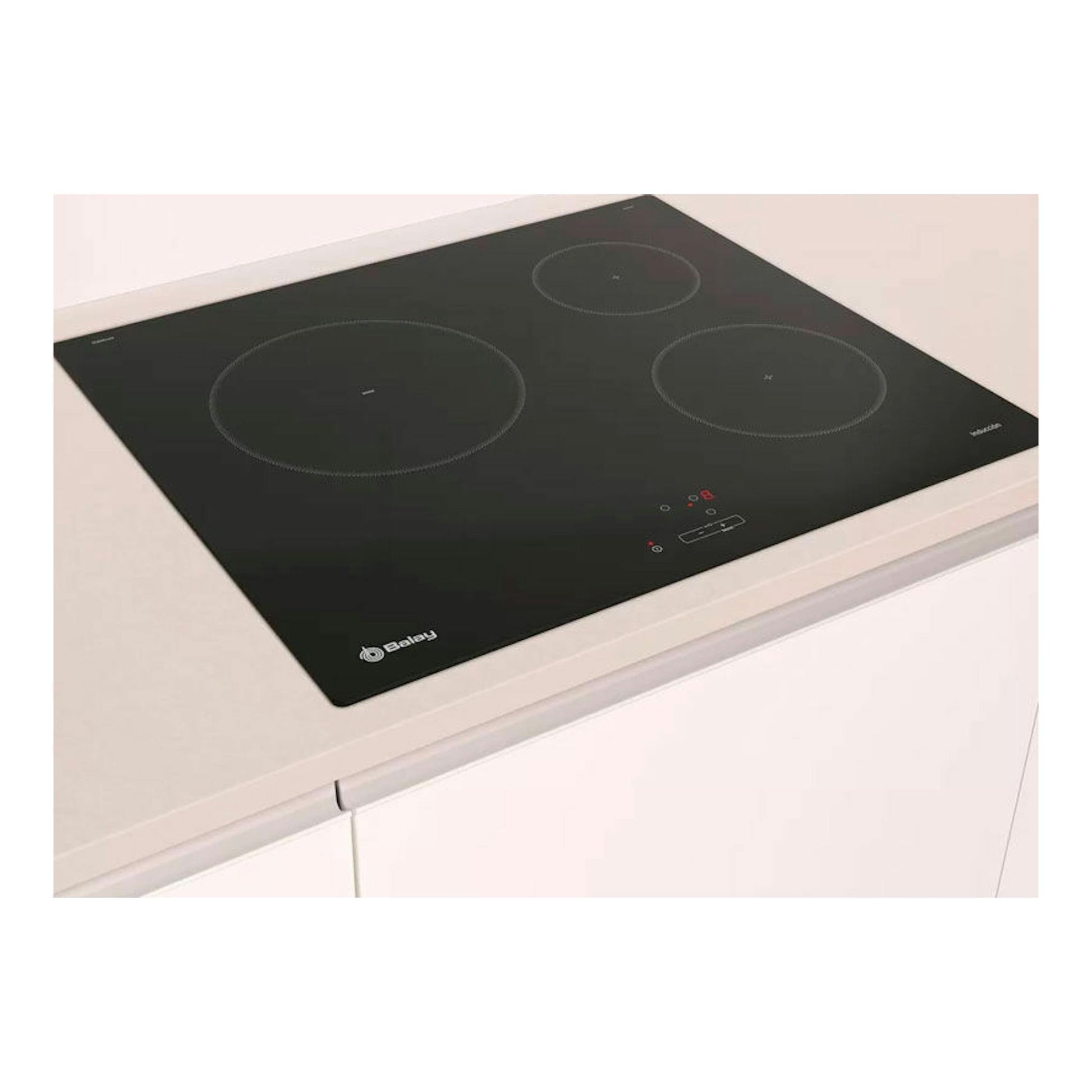 Placa de inducción Balay 3EB864EN negra, vista en ángulo sobre encimera blanca, con tres zonas de cocción.