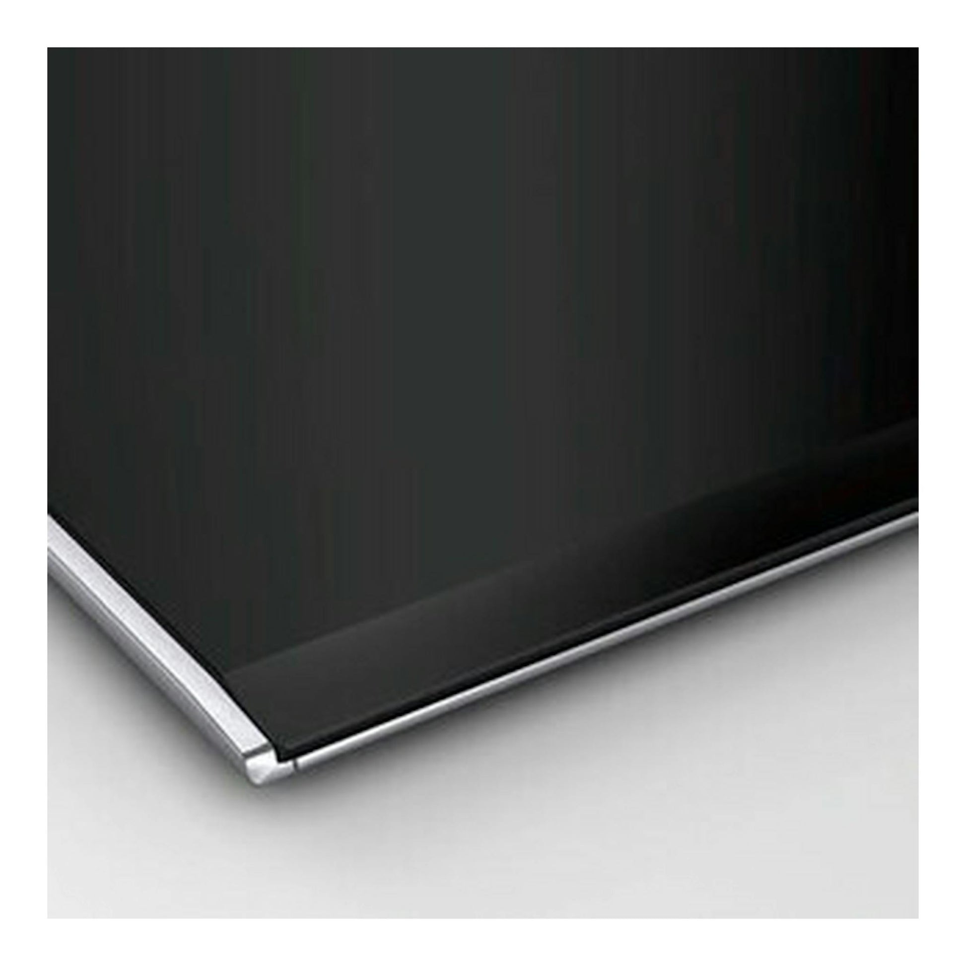 Placa de inducción Bosch PXY675DC1E negra, primer plano de una esquina con borde plateado.