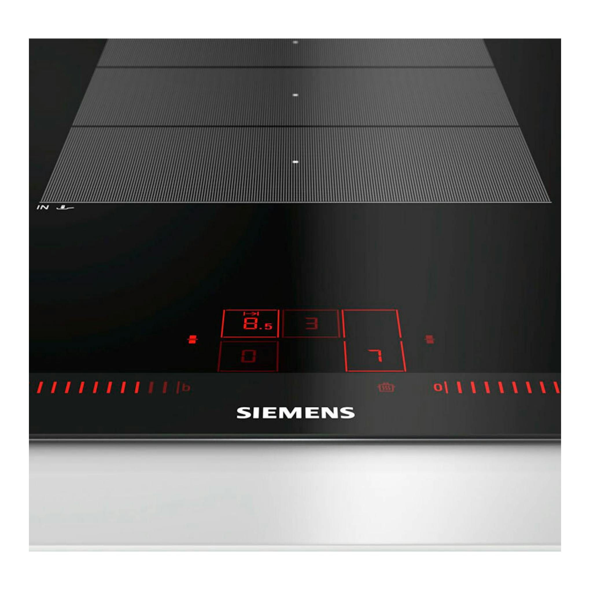 Placa de inducción Siemens EX975LXC1E negra, vista frontal en ángulo, con controles táctiles rojos.