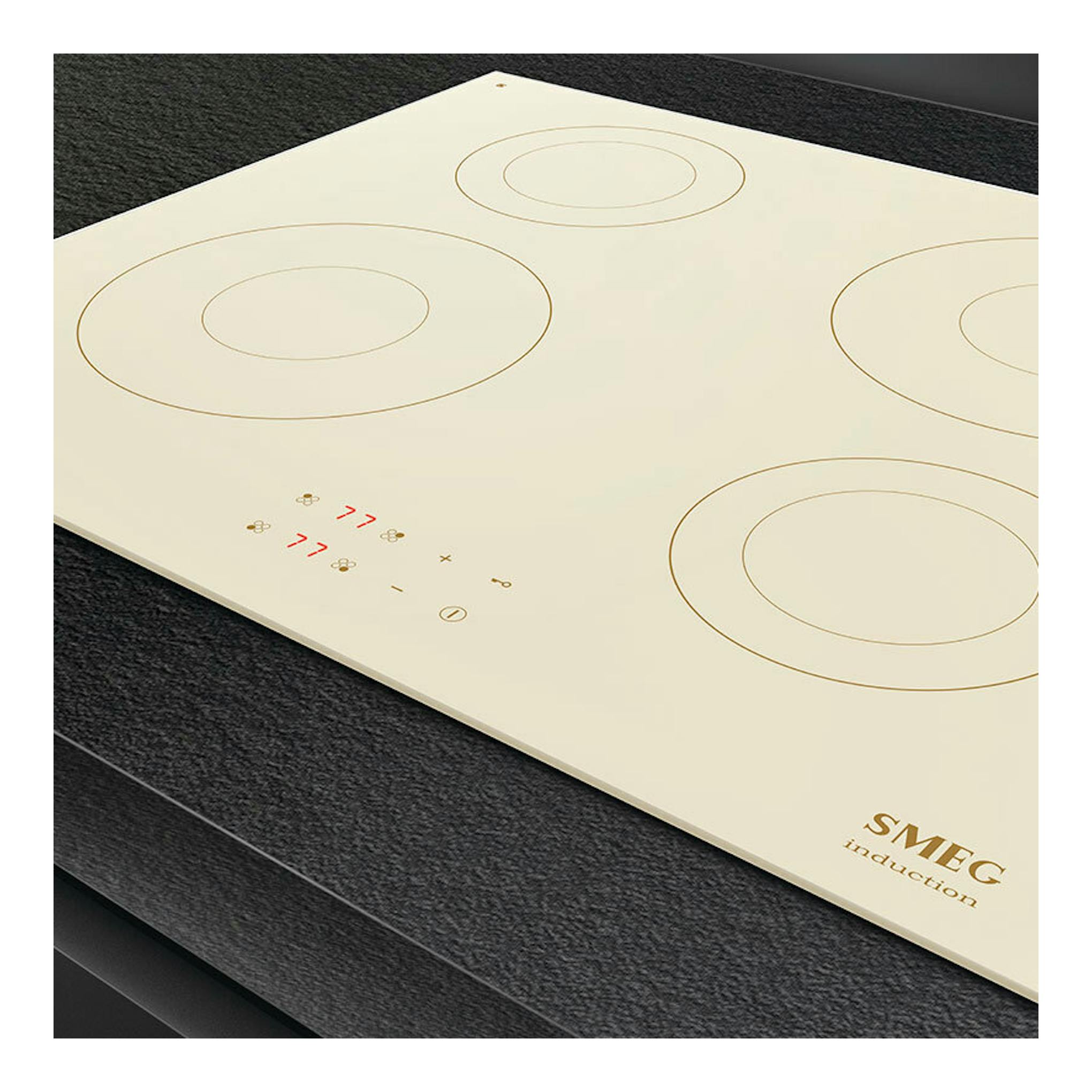 Placa de inducción Smeg SI2641DP beige, vista en ángulo, con 4 zonas de cocción circulares.