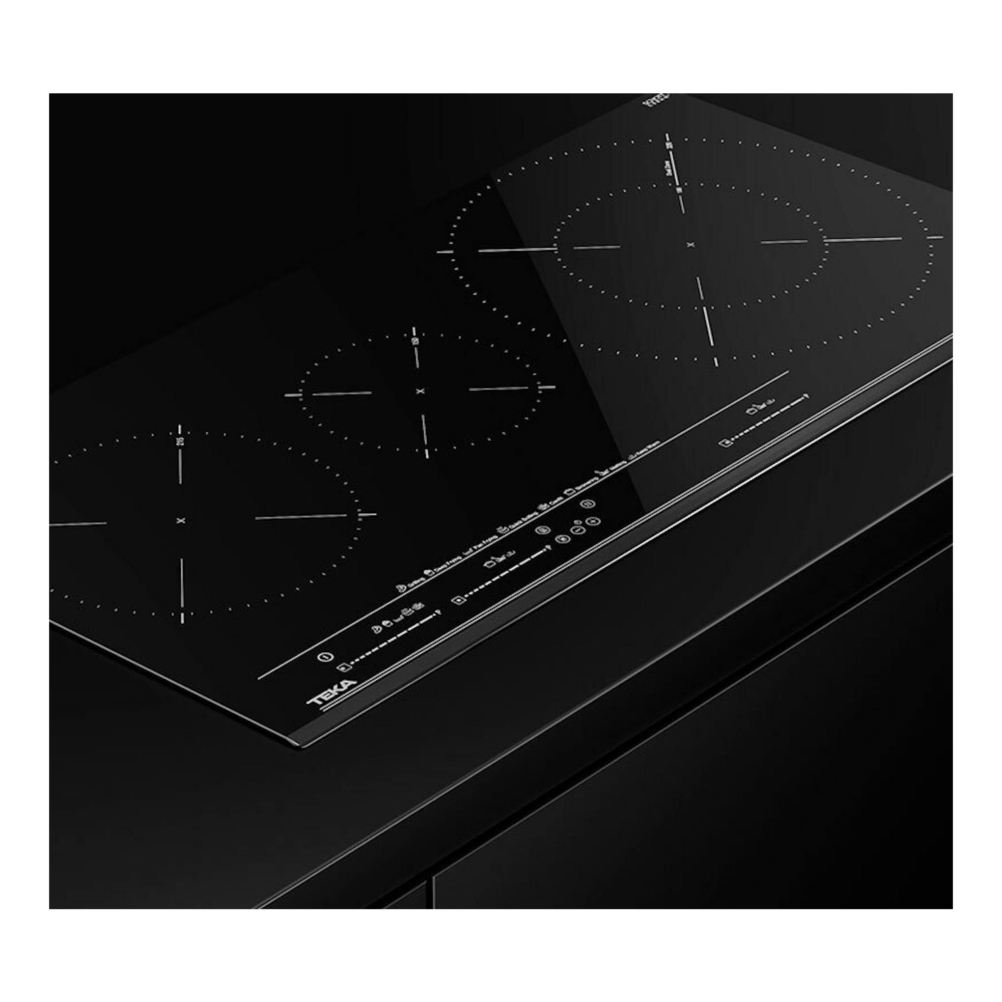 Placa de inducción Teka IZC83620MST negra, vista en ángulo con cuatro zonas de cocción.