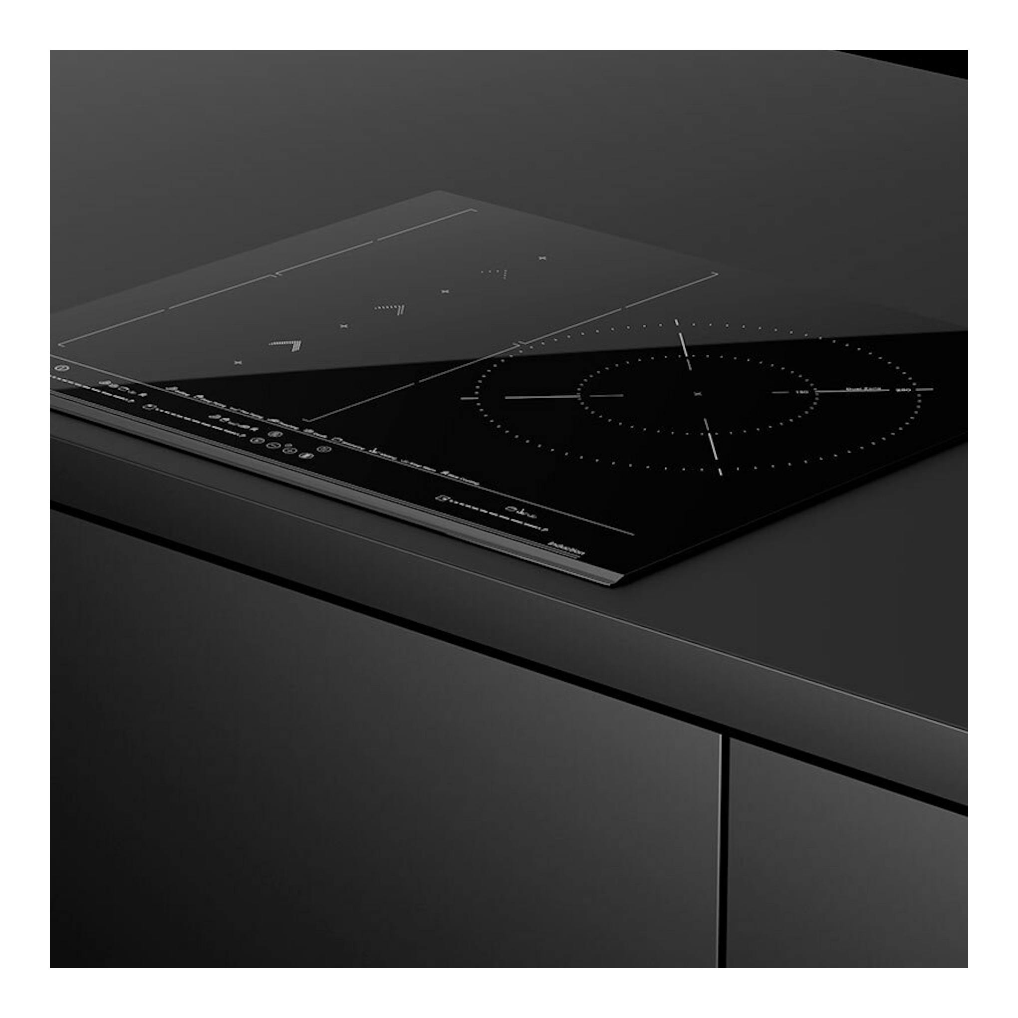 Placa de inducción Teka IZS67620MST negra, vista en ángulo sobre encimera oscura.