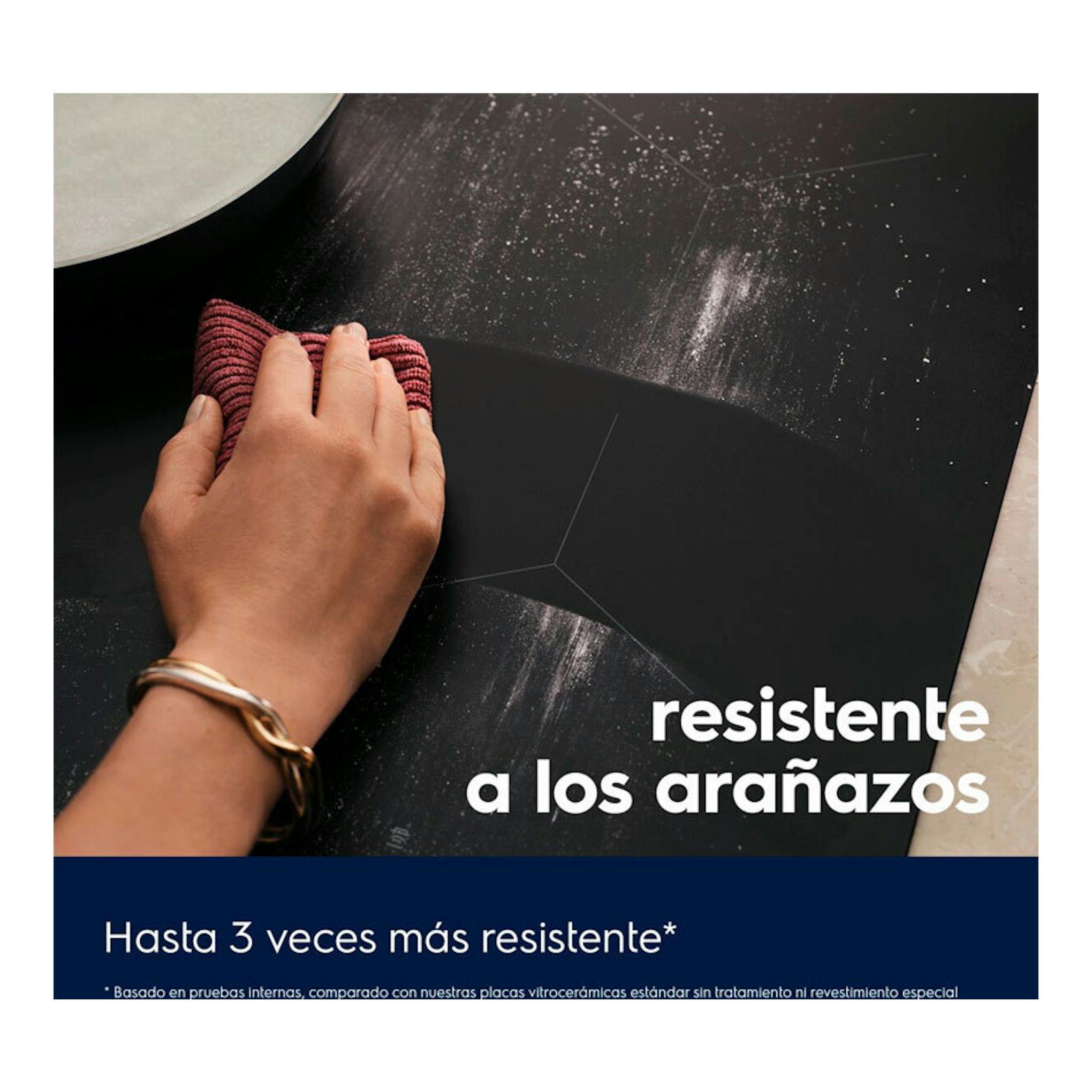 Placa de inducción Electrolux EIT61336 negra, vista superior, con una mano limpiando la superficie.