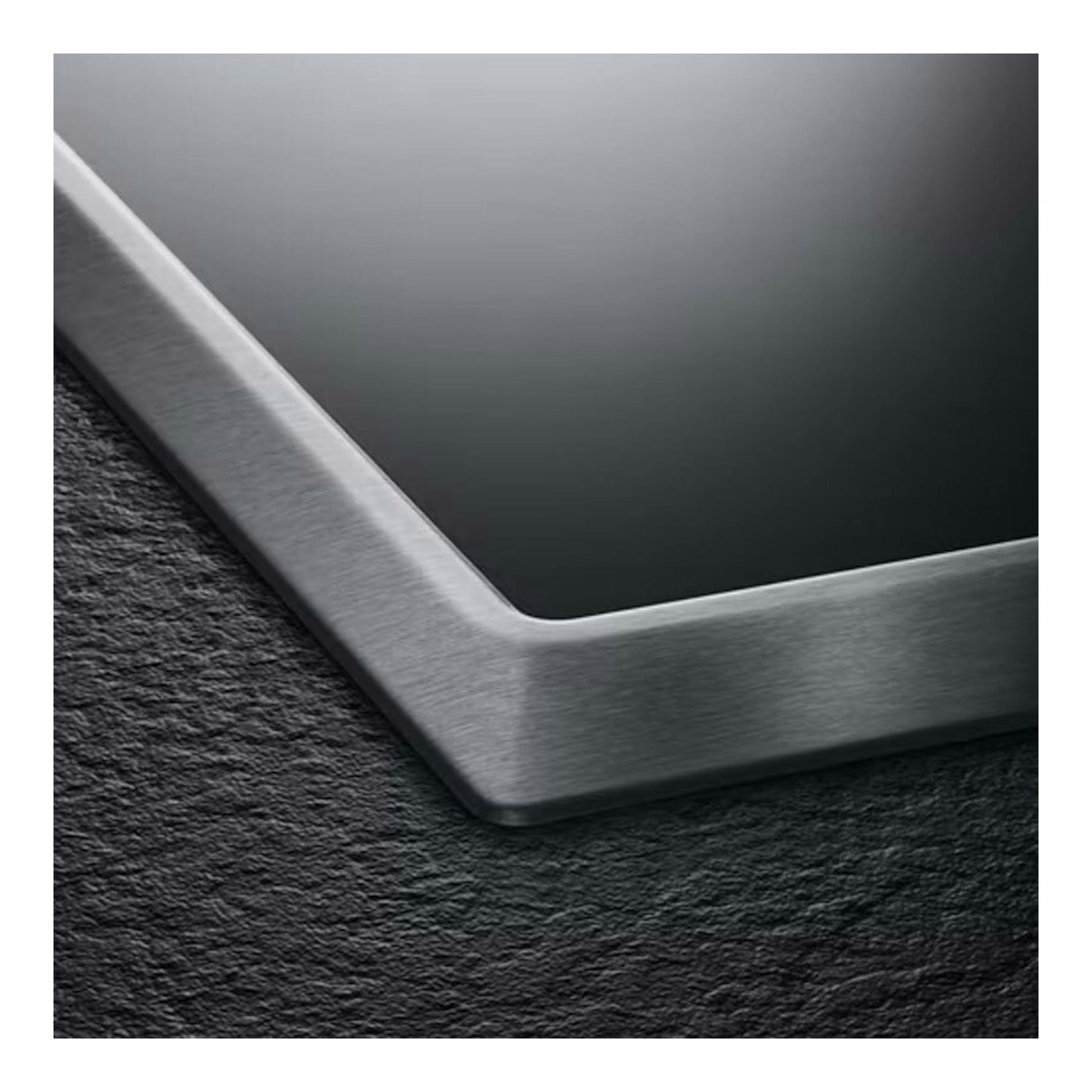 Placa vitrocerámica AEG HK634060XB, esquina en primer plano de vidrio negro con marco de acero inoxidable.