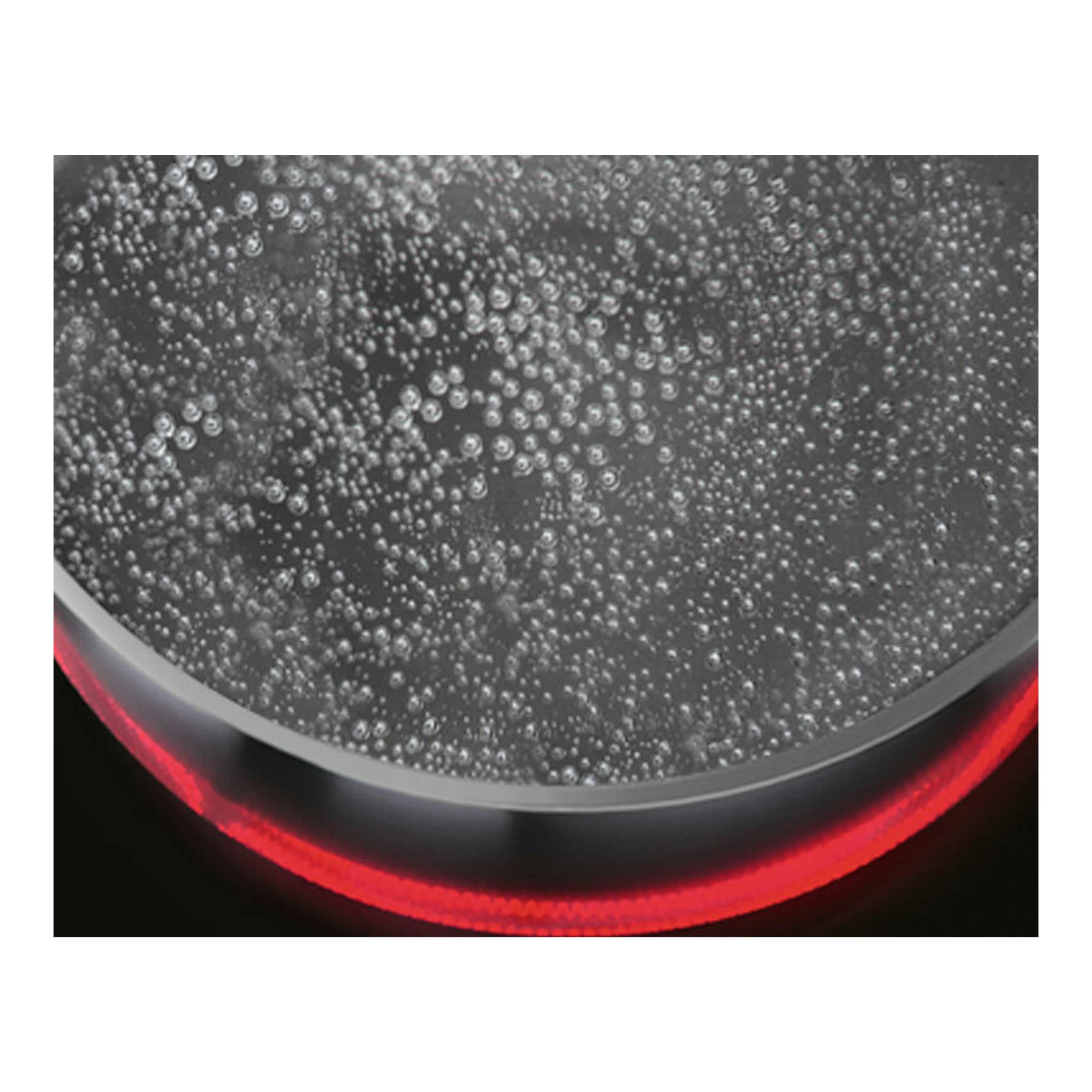 AEG HK634060XB: primer plano de una olla con agua hirviendo sobre placa vitrocerámica negra, aro rojo encendido.