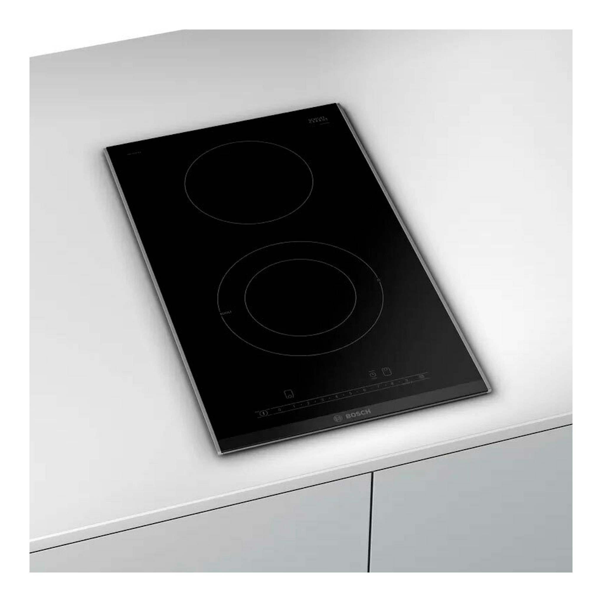 Placa vitrocerámica Bosch PKF375FP2E negra, vista en ángulo, con dos zonas de cocción.