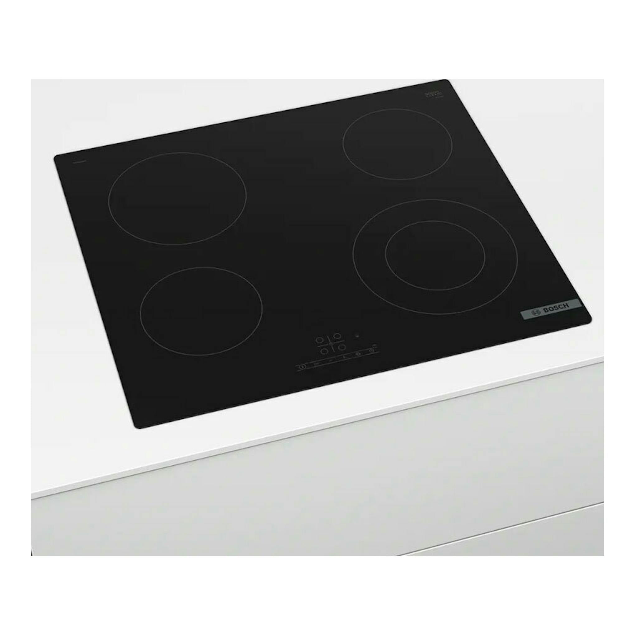 Placa vitrocerámica Bosch PKF611BB8E negra, vista en ángulo superior, con cuatro zonas de cocción.