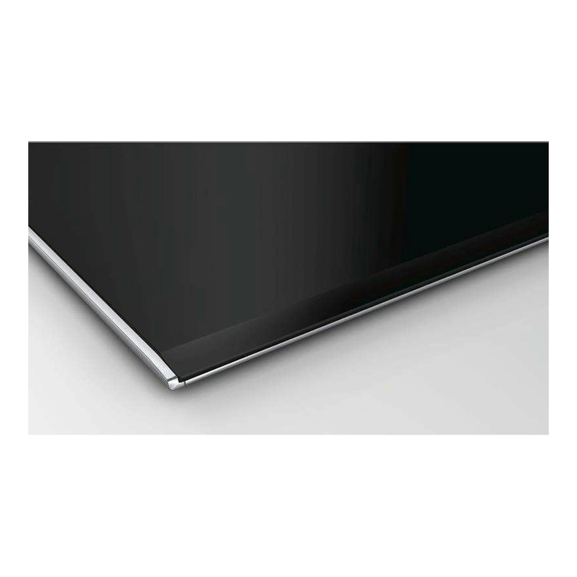 Placa vitrocerámica Bosch PKM875DP1D negra, vista en primer plano de una esquina con borde metálico.