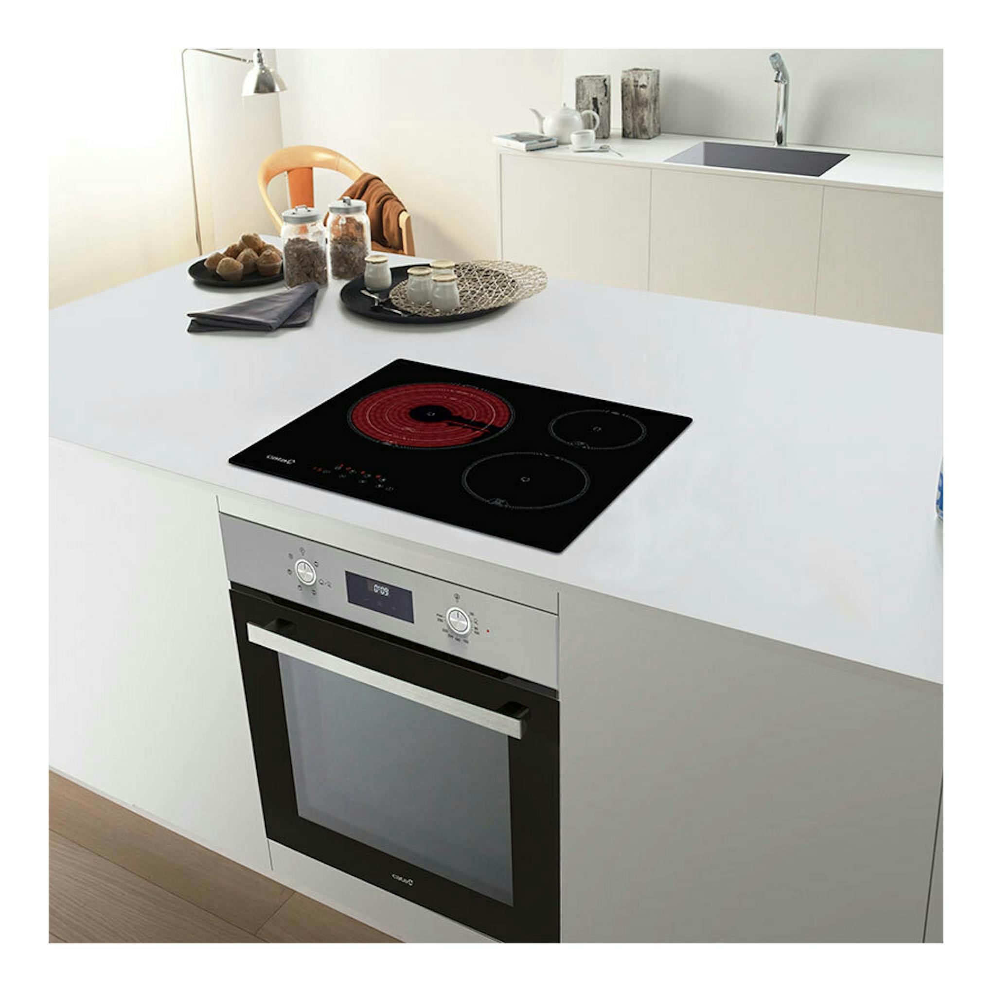 Placa vitrocerámica Cata TT6003 e-tech negra, vista en ángulo, sobre encimera blanca.