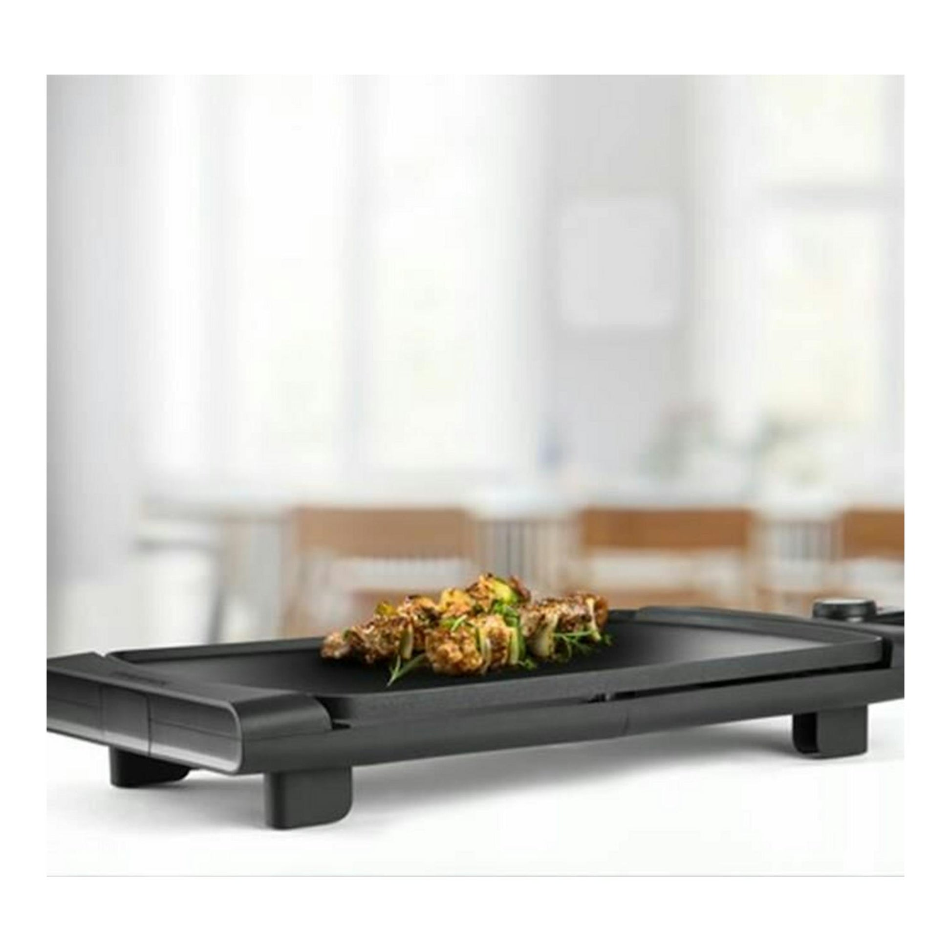 Plancha asar Taurus Steakmax 2600 negra, vista en ángulo, con comida en la superficie.