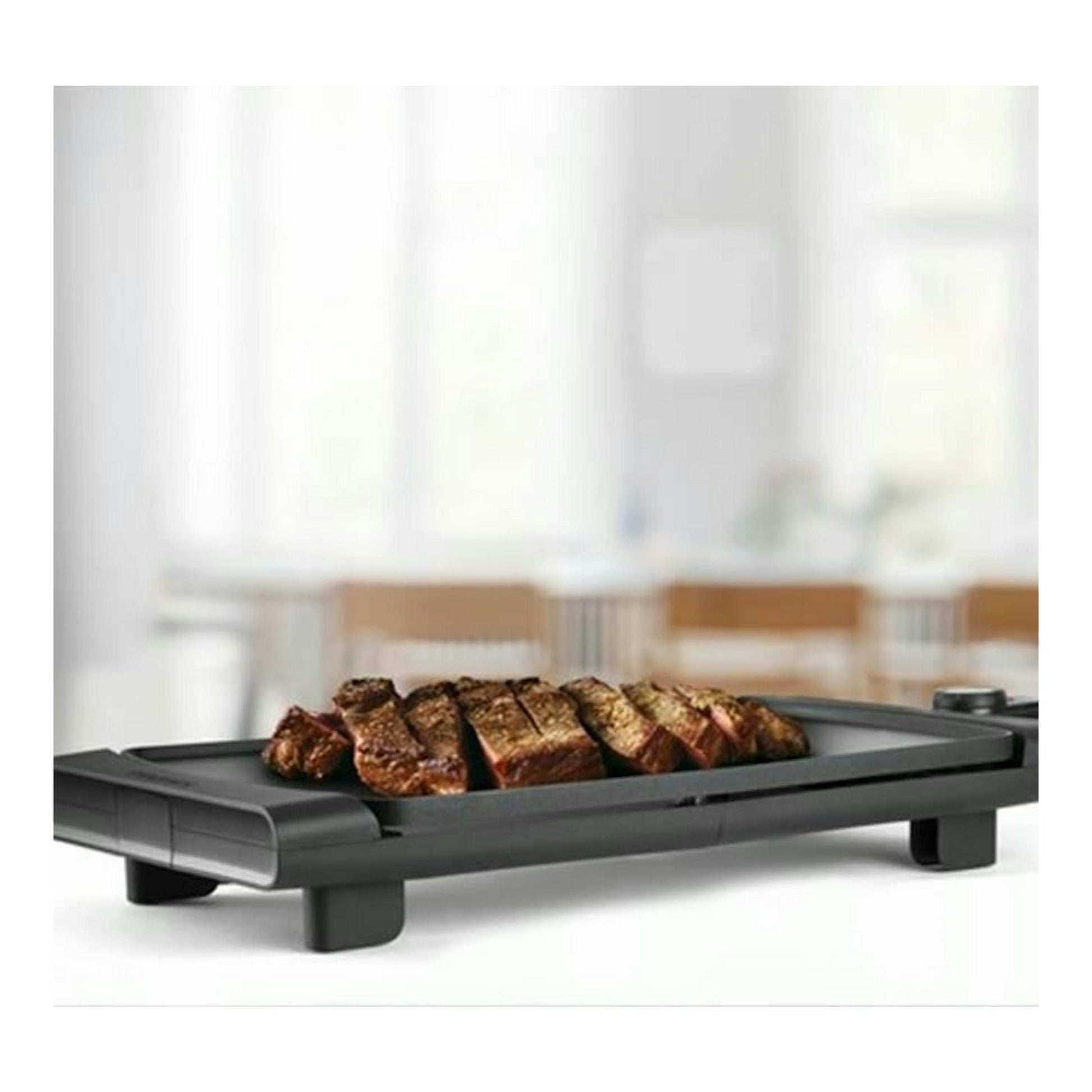 Plancha de asar Taurus Steakmax 2600 negra, en vista en ángulo, con carne asada.