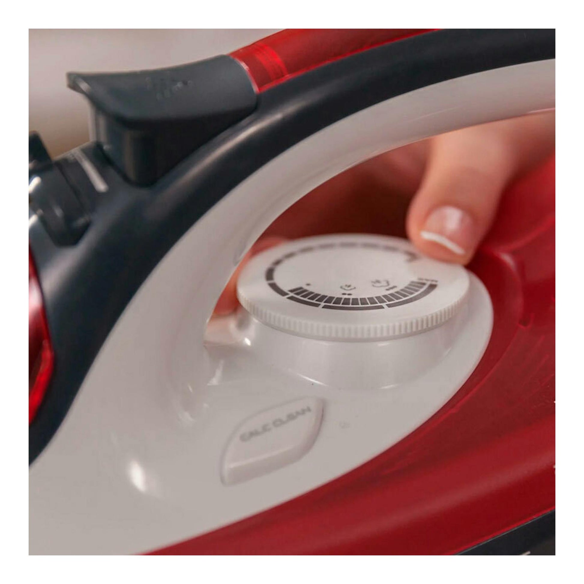 Plancha de vapor Solac en primer plano, con dial blanco y cuerpo rojo y negro.