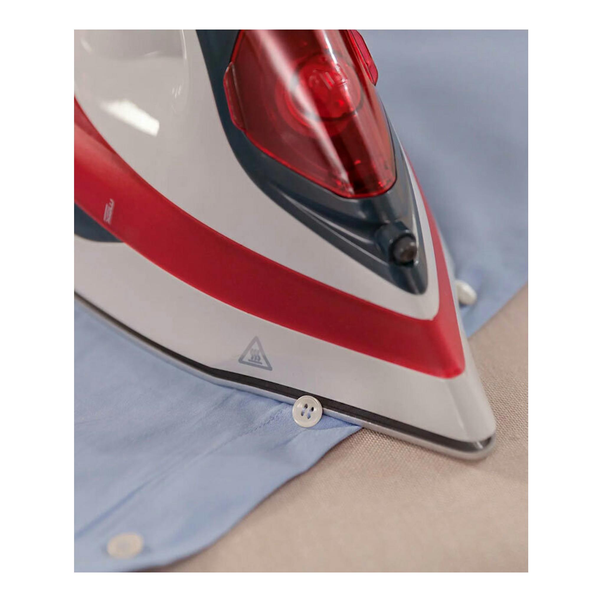 Plancha de vapor Solac PV2014, primer plano de una plancha blanca y roja sobre una camisa azul.