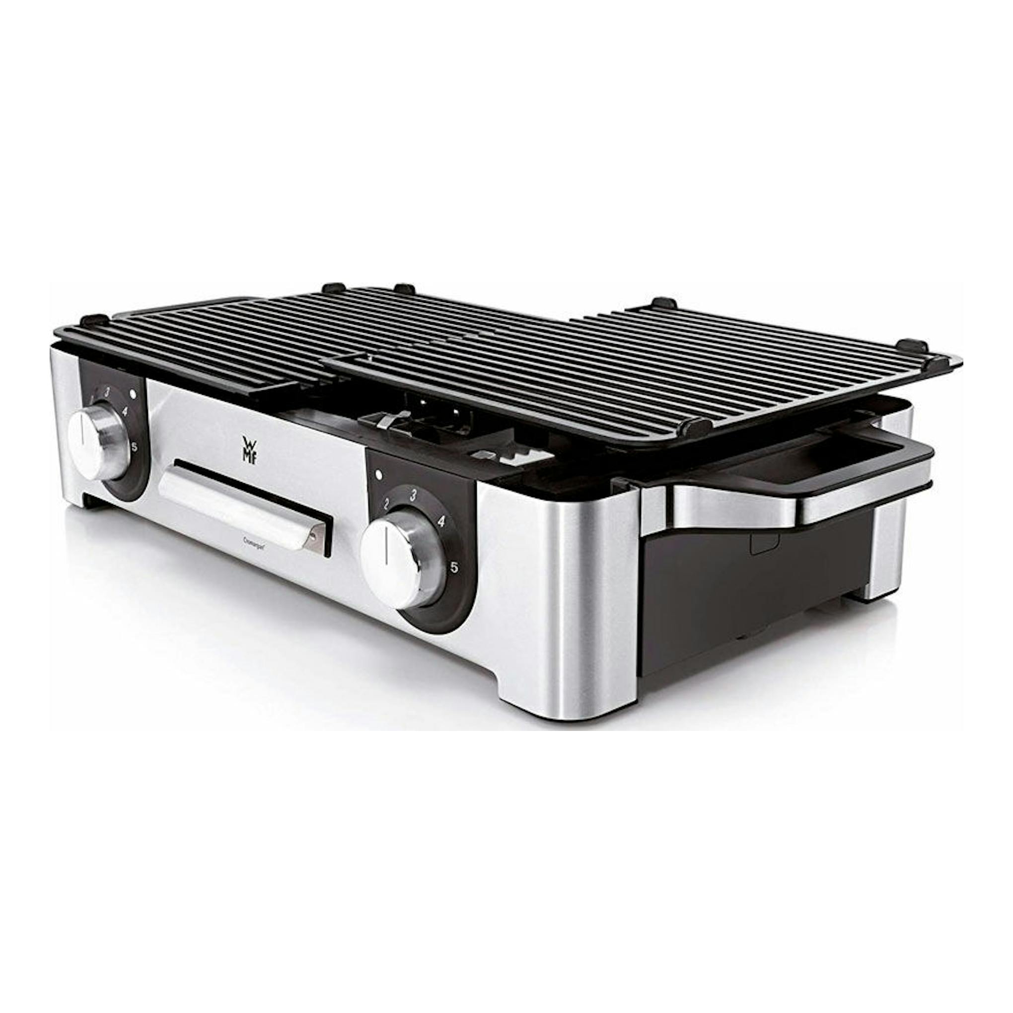 Grill eléctrica WMF LONO, vista en 3/4, cuerpo de acero inoxidable y negro, con dos placas acanaladas abiertas.