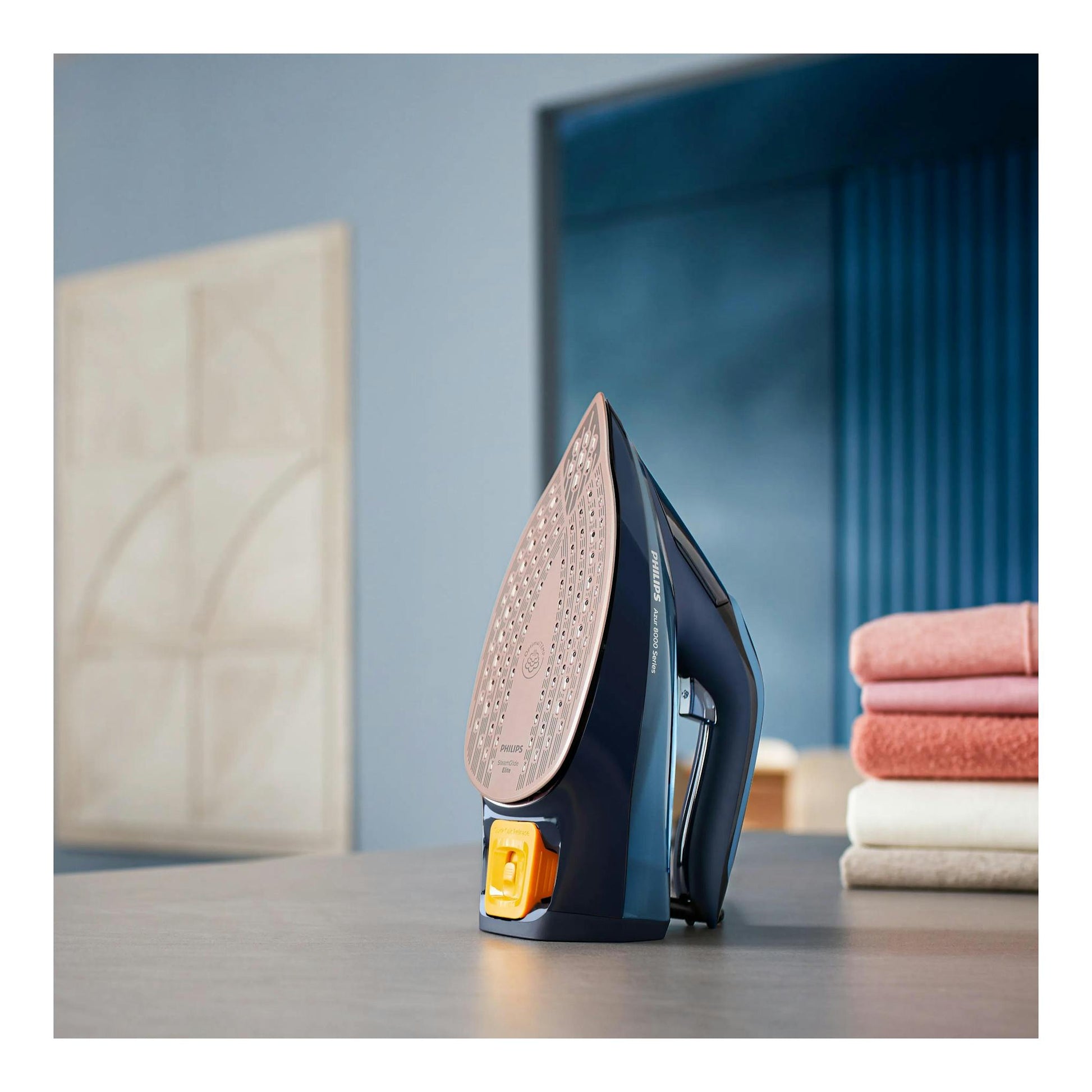 Plancha de vapor Philips Azur 8000 Series DST8020/20, vista lateral, azul oscuro con suela rosa y botón amarillo.