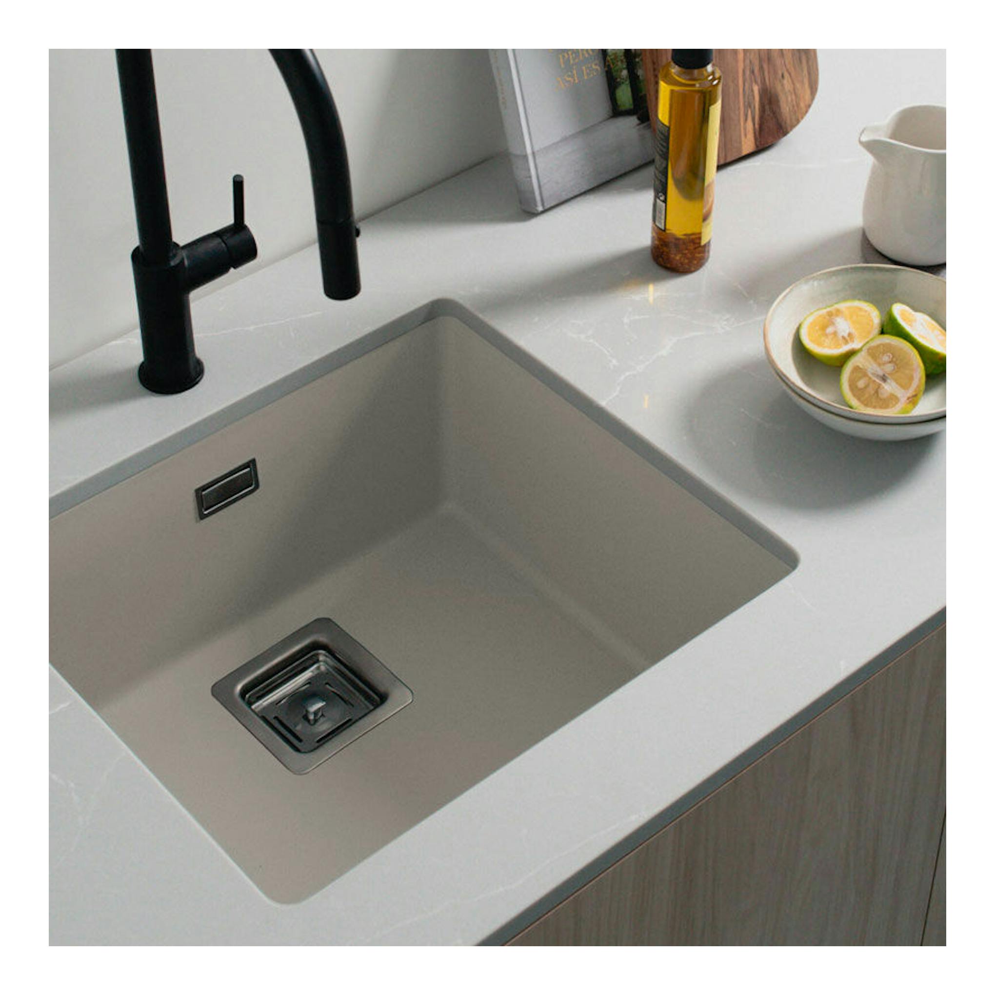 Fregadero Poalgi Zie 45 1/S beige pumice, vista cenital inclinada, con grifo negro y encimera gris.