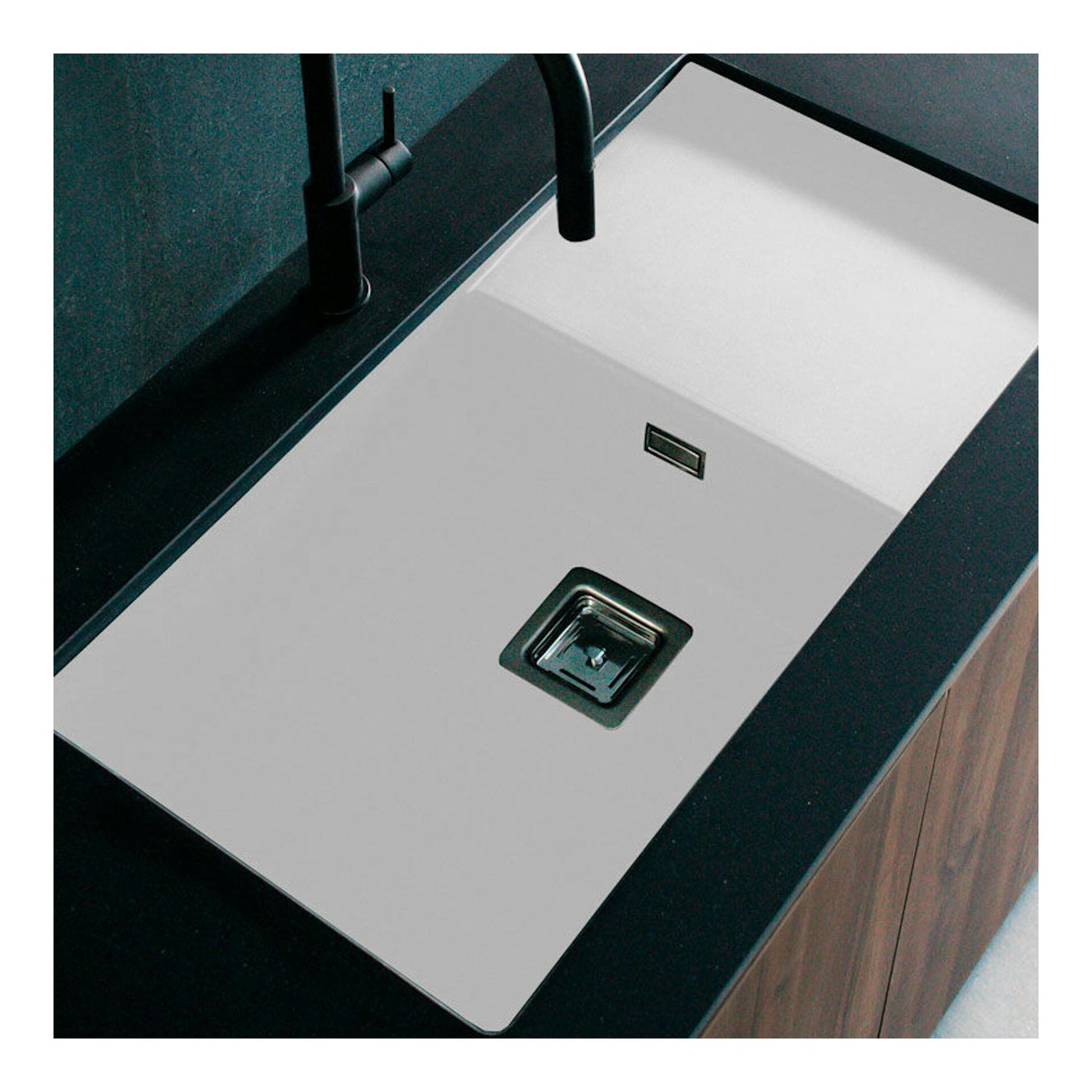 Fregadero Poalgi Zie 81 1/S+E blanco, vista cenital en encimera negra, con grifo negro.