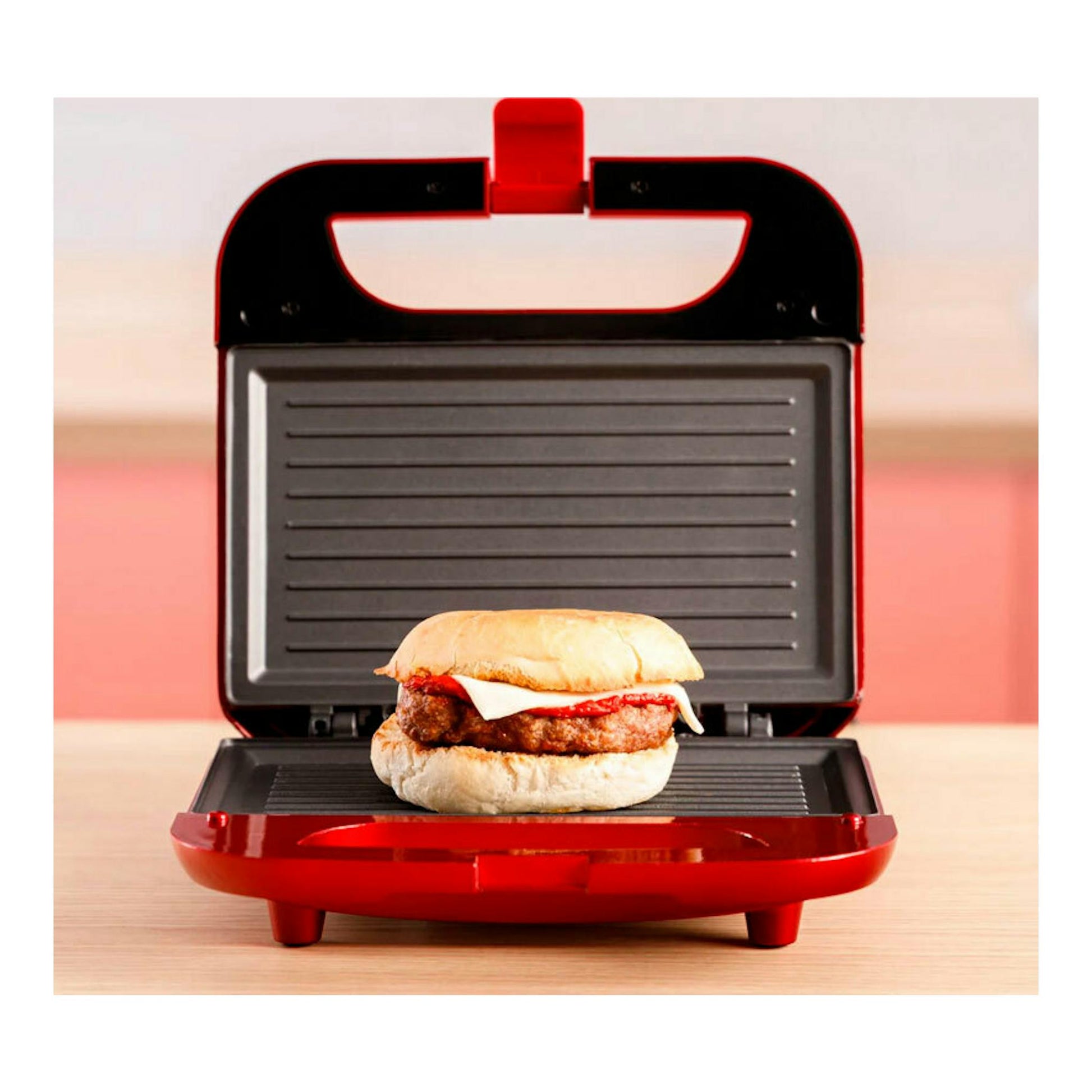Sandwichera Solac SD5058 roja y negra, abierta en vista frontal, con un sándwich dentro.