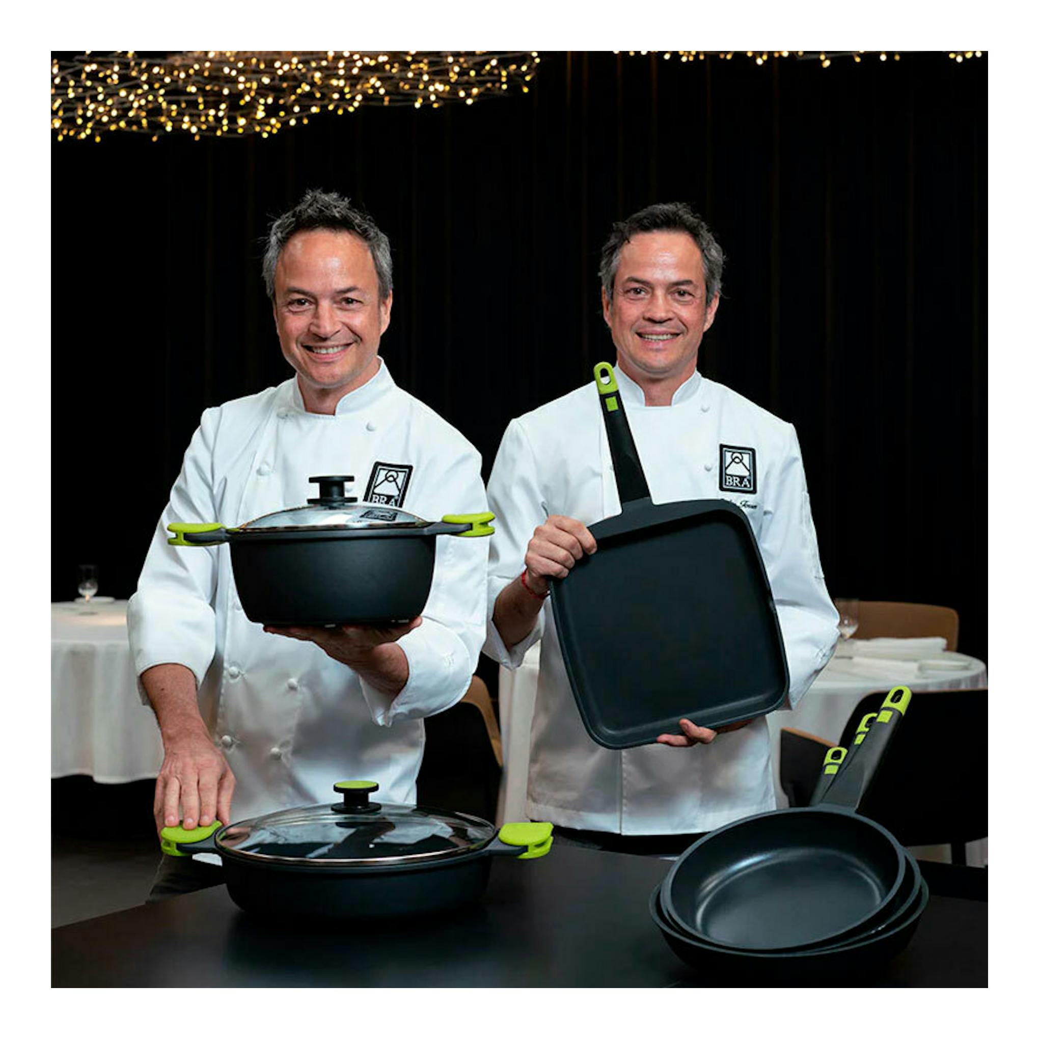 Dos chefs muestran sartén y plancha Bra 30 Foodie negras con mango verde.