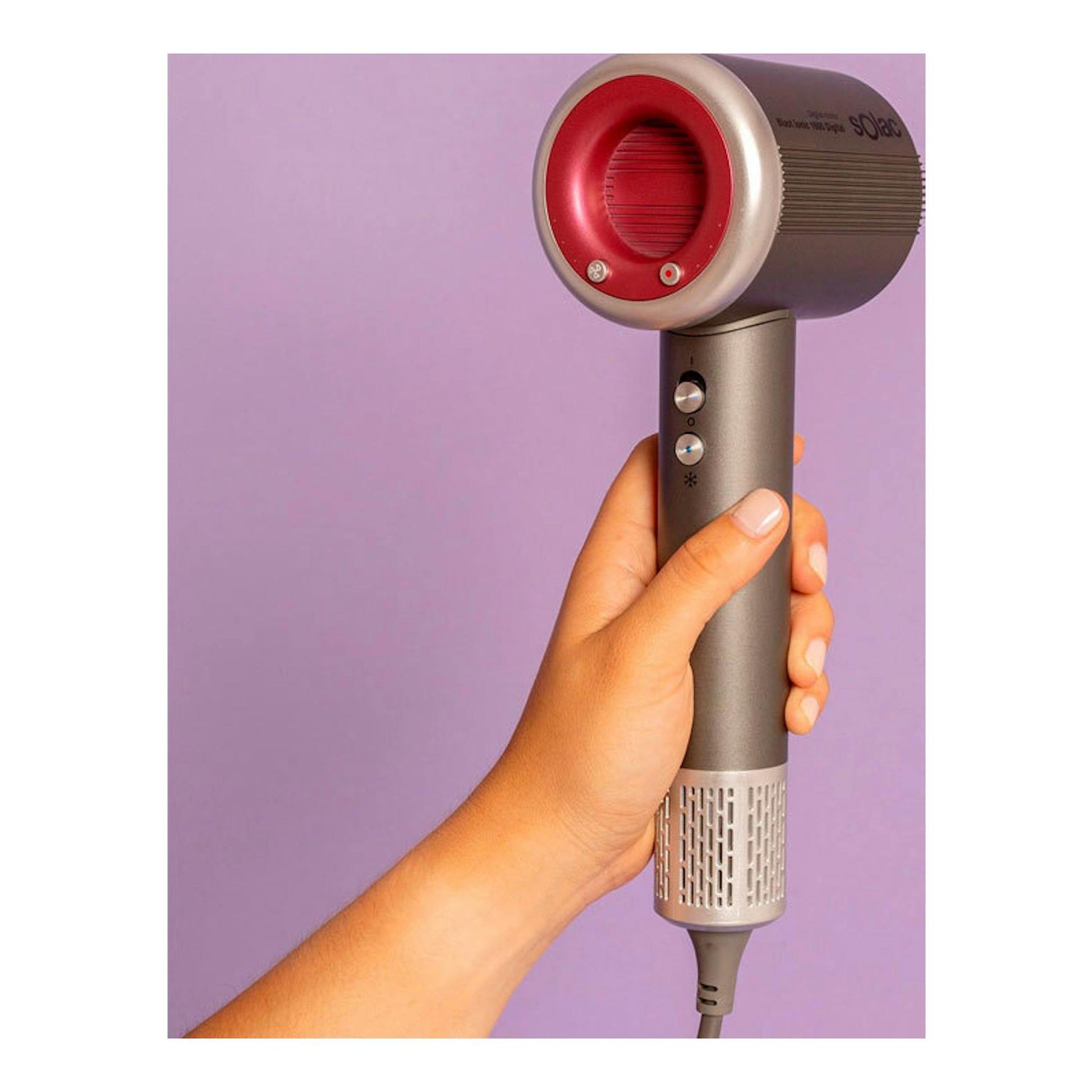 Secador Solac SB7950 Blast Ionic 1600 Digital gris y rosa, visto de frente y sostenido con una mano.