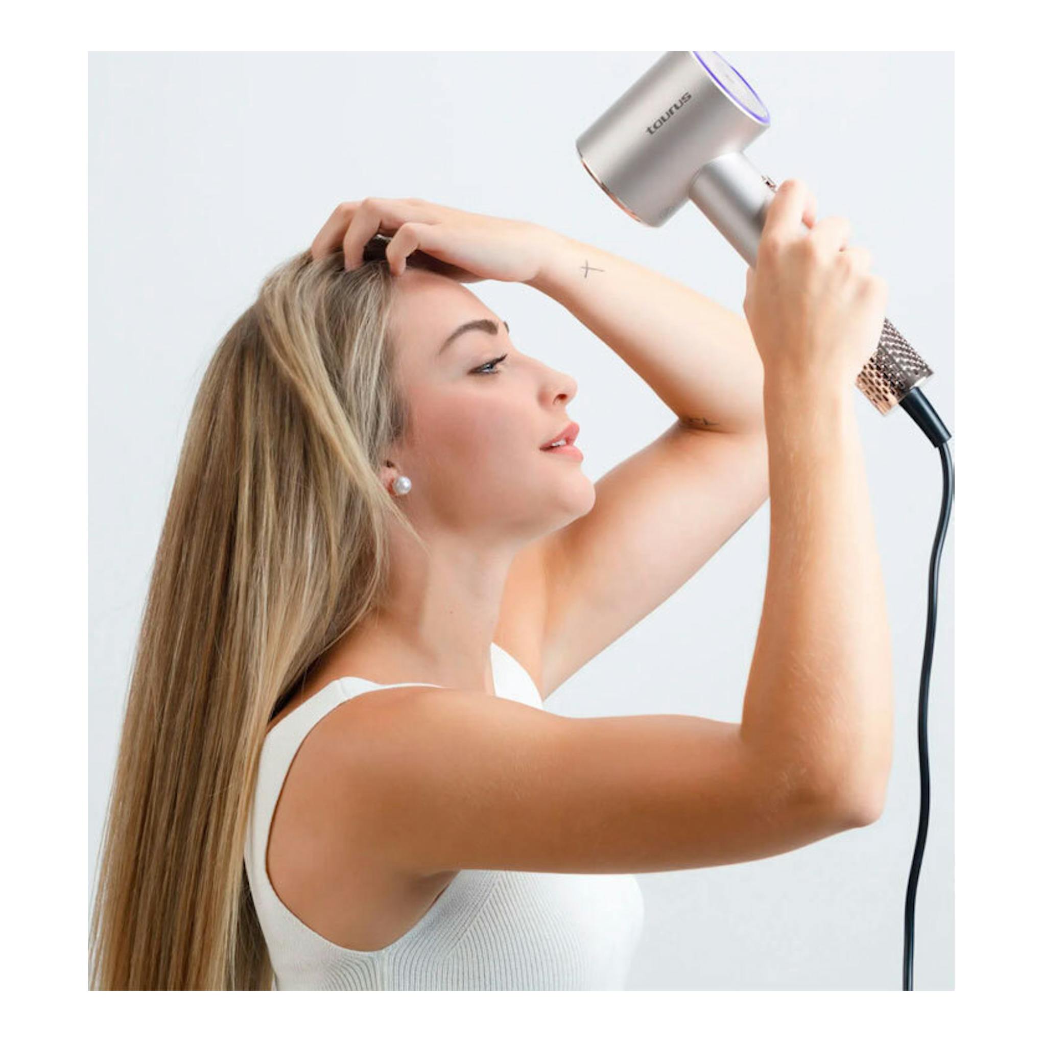 Secador Taurus Digital Force Protect plateado, en vista lateral, usado por una mujer de perfil.