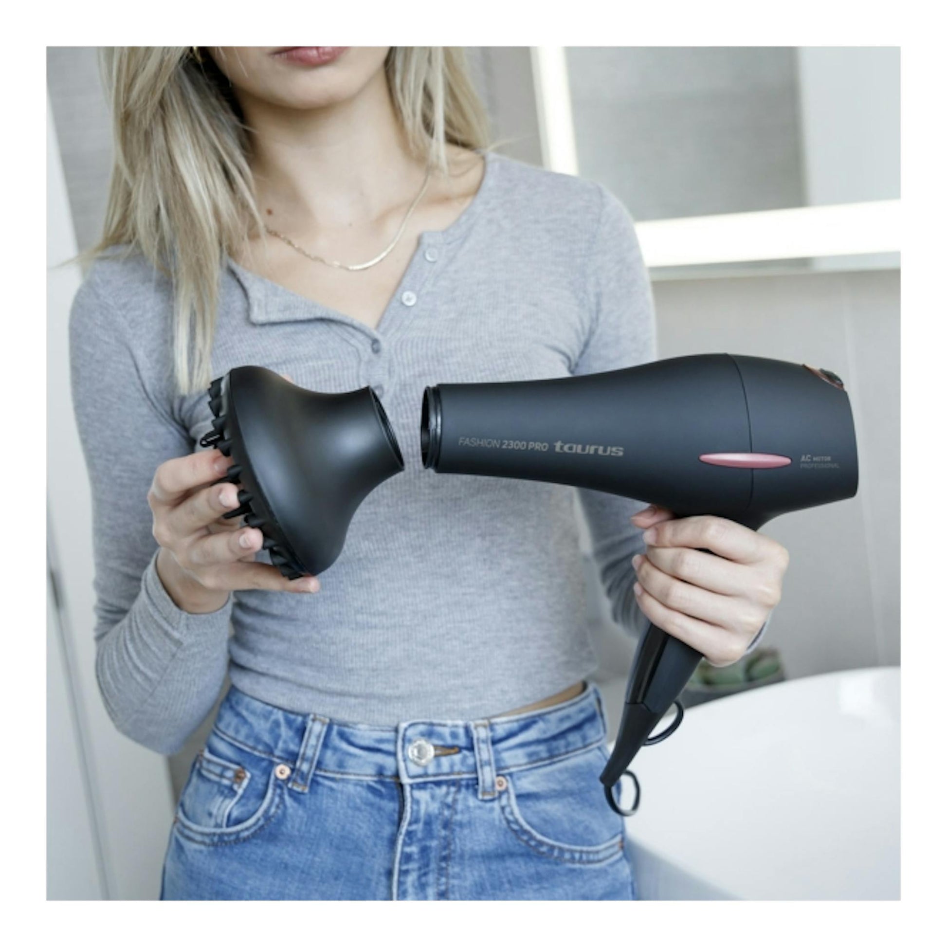 Secador de pelo Taurus Fashion 2300 Pro negro, con difusor, sujetado por una mujer.