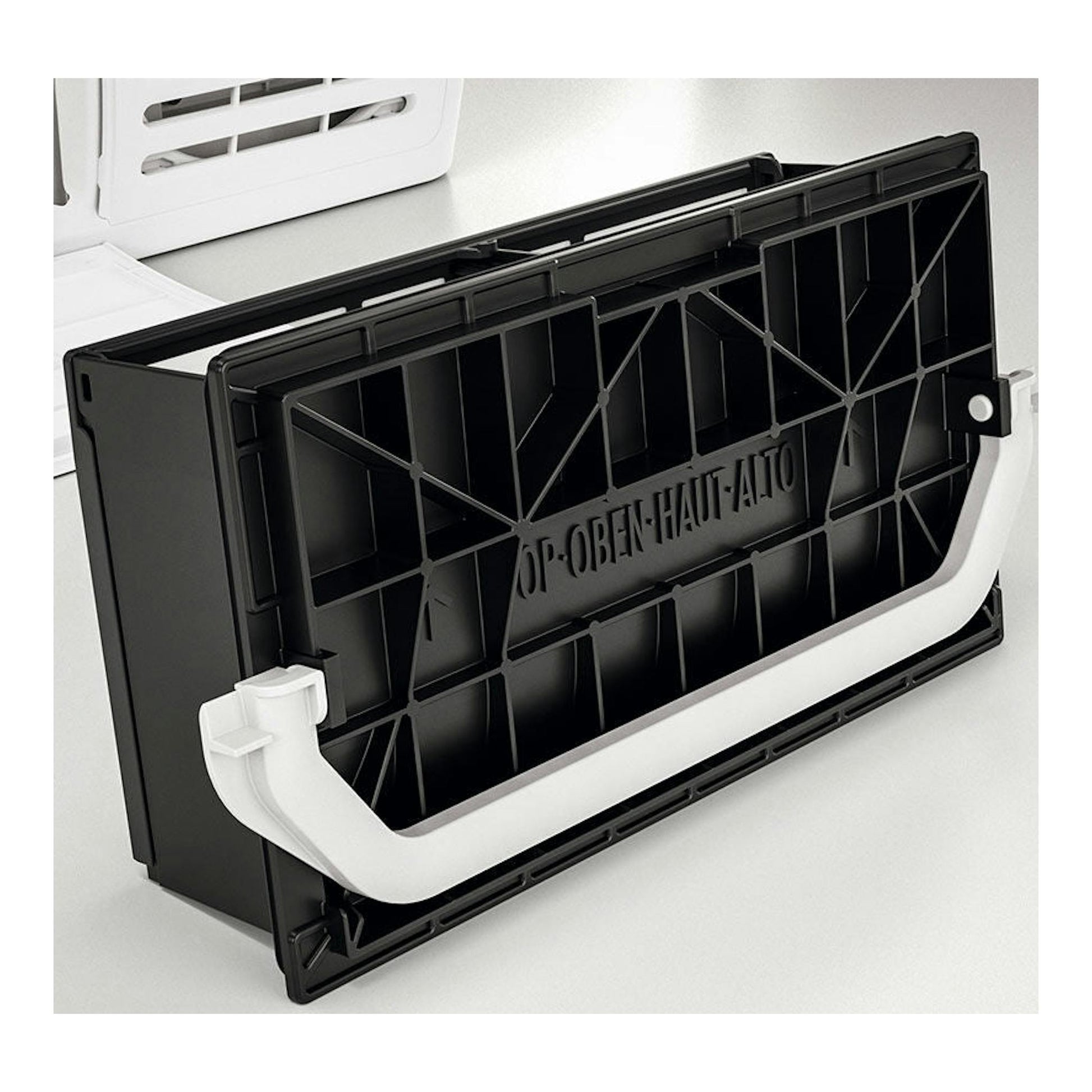 Pieza plástica negra rectangular con asa blanca, vista frontal, con texto en relieve.