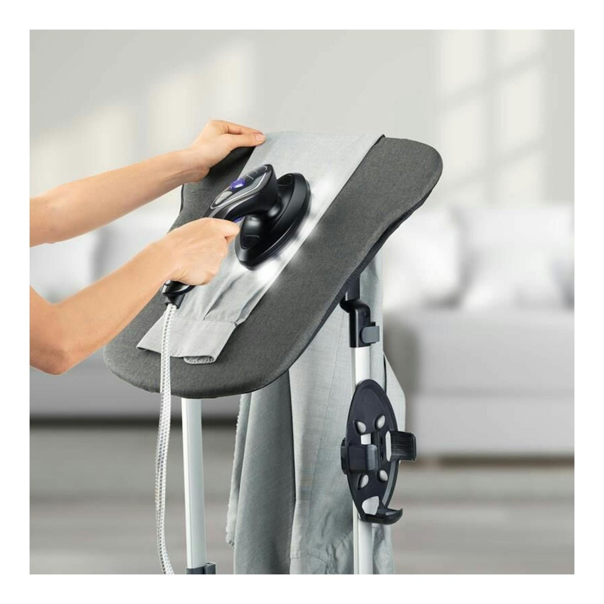 Sistema de planchado Taurus Sliding Care Non Stop, vista frontal oblicua, tabla gris con plancha negra en uso.