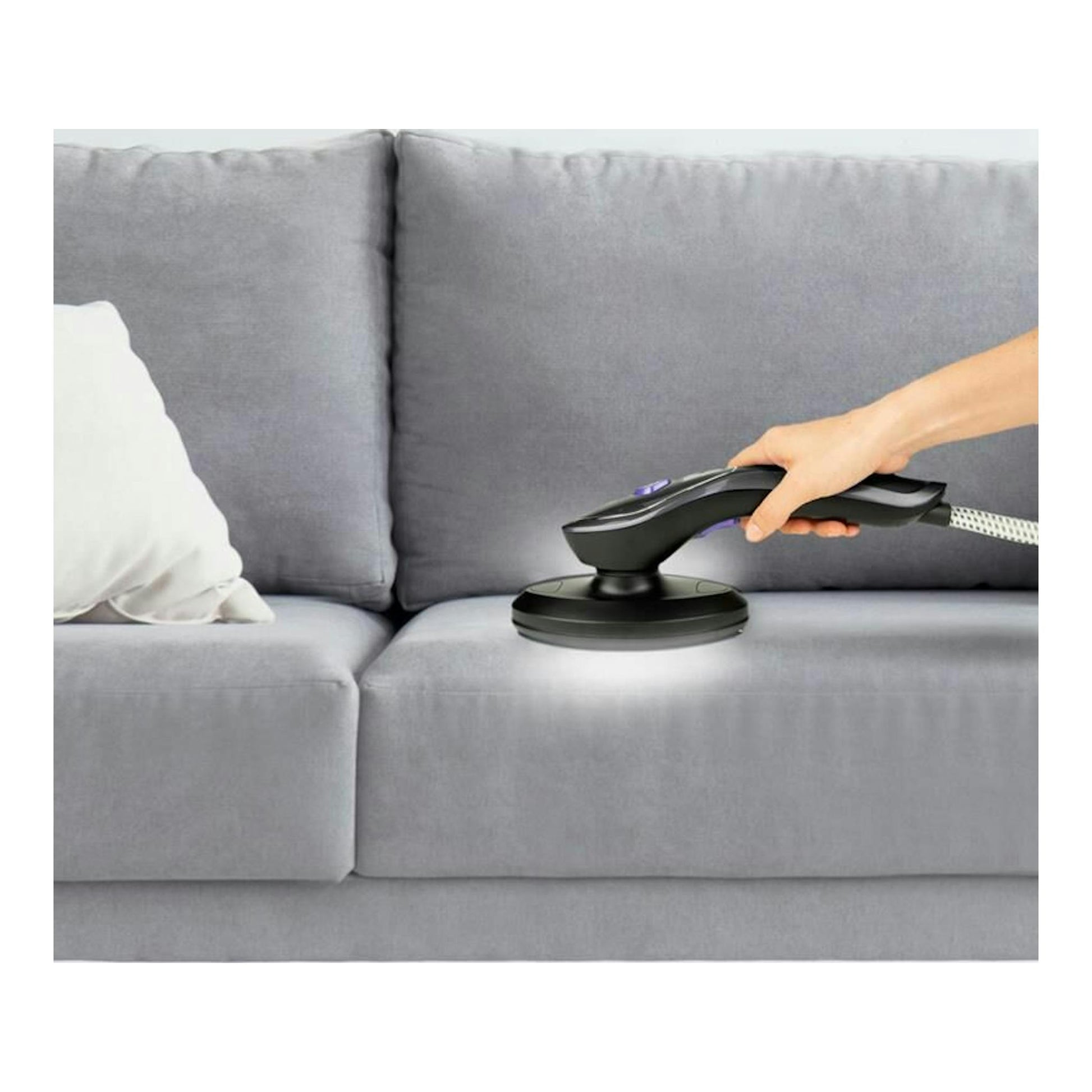 Sistema de planchado Taurus Sliding Care Non Stop negro, en mano sobre un sofá gris, vista lateral.