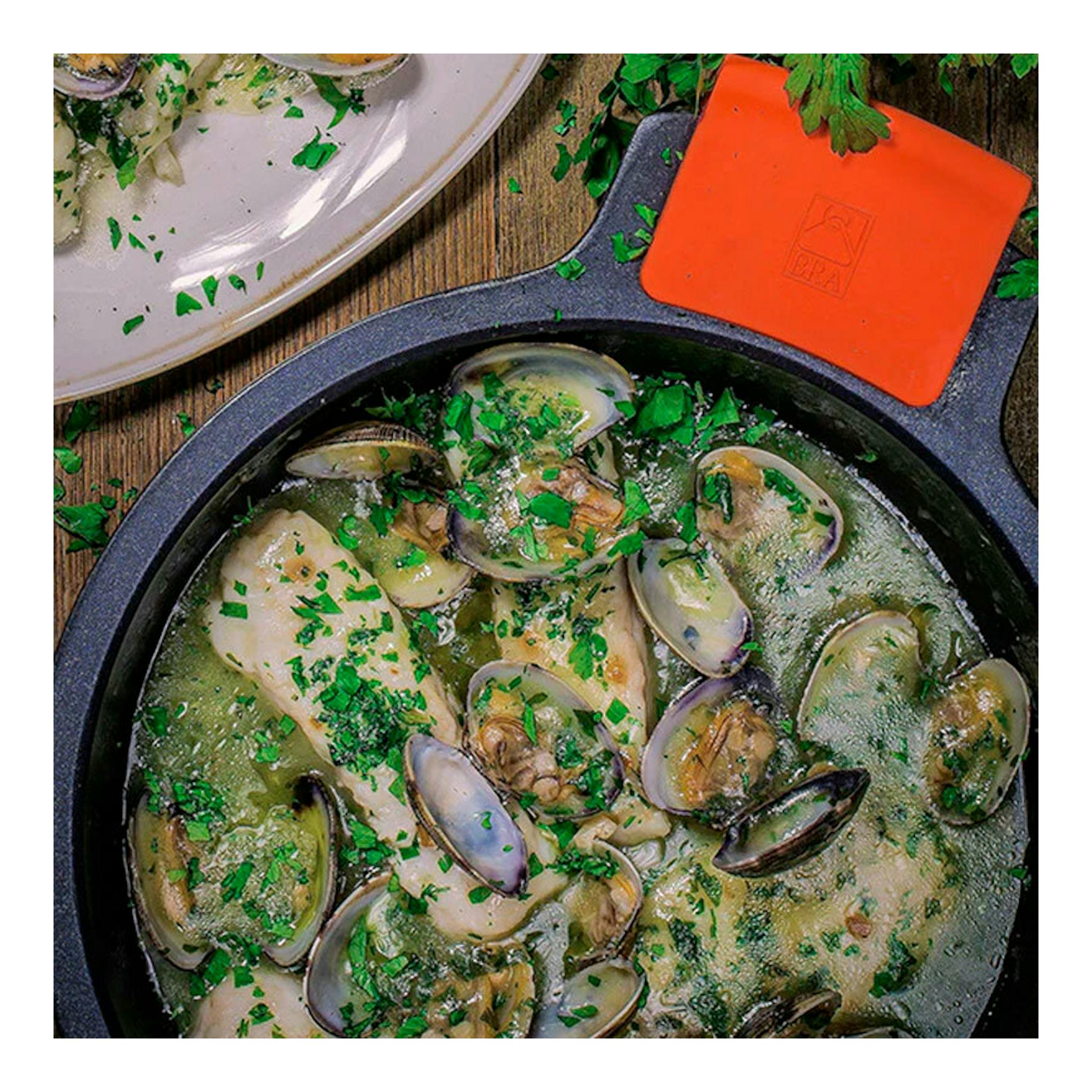 Cacerola alta Bra Efficient negra, vista superior, con mejillones y salsa.