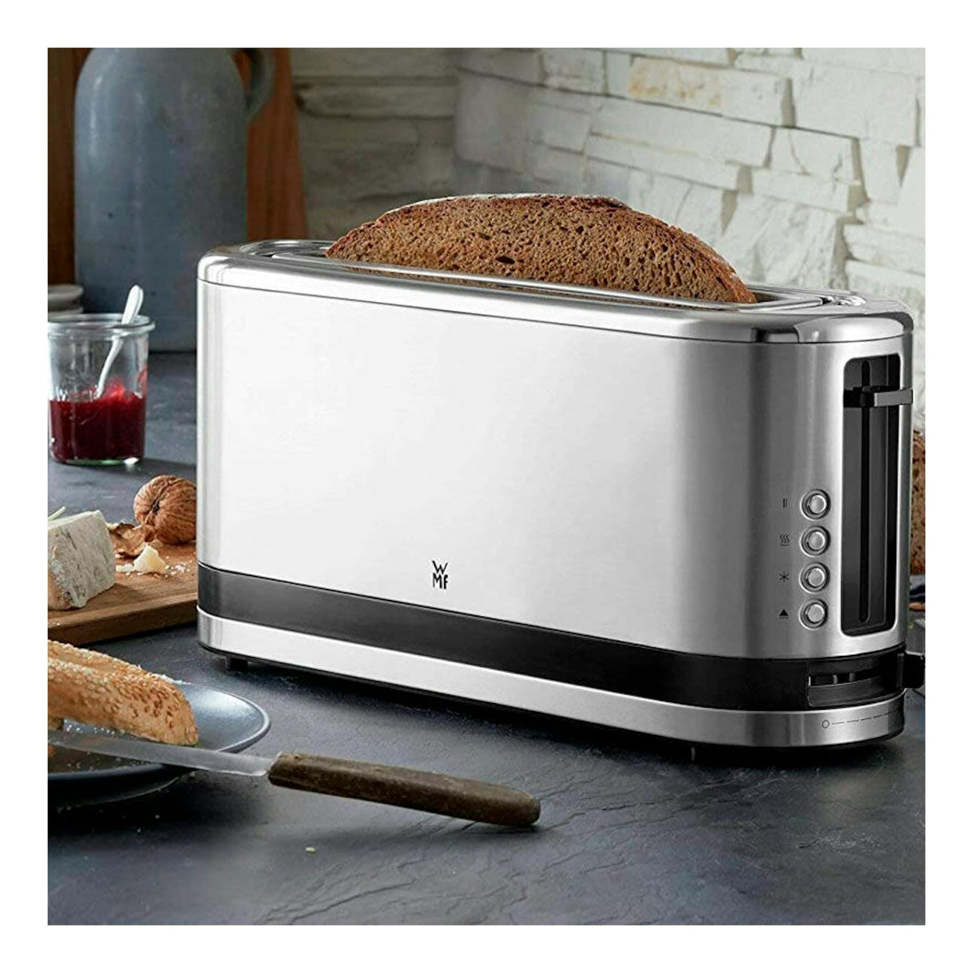 WMF Kitchenminis tostador de 1 ranura, plateado, vista lateral con una rebanada de pan en la ranura.