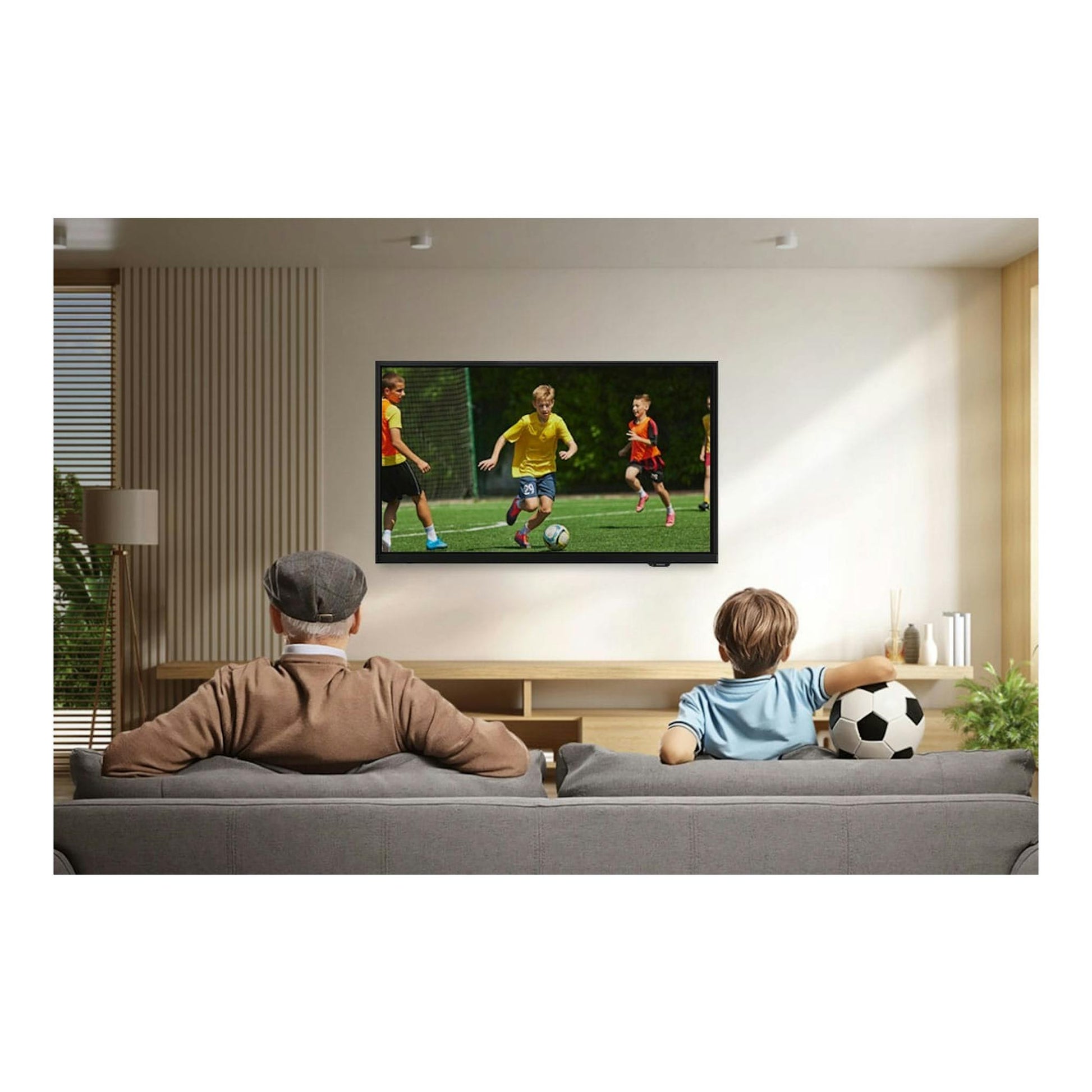 Samsung TU27F6005FKXXC, televisor negro de frente montado en pared, mostrando un partido de fútbol infantil.
