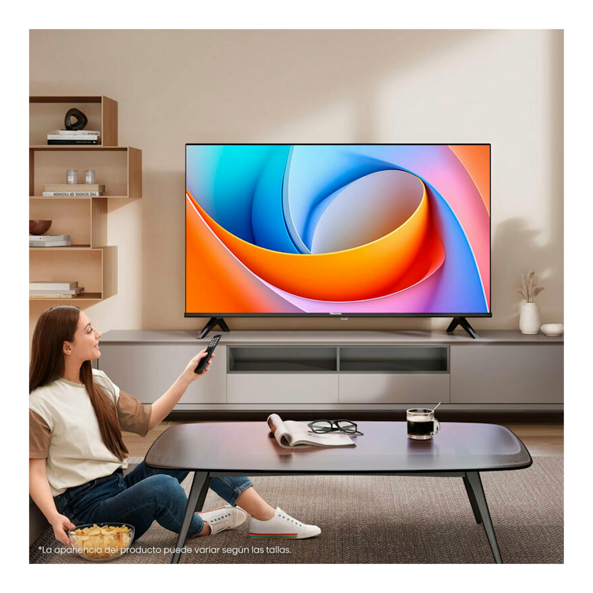 TV Hisense 32A4Q LED de 32" en salón, vista frontal, con una mujer sentada y mando a distancia.