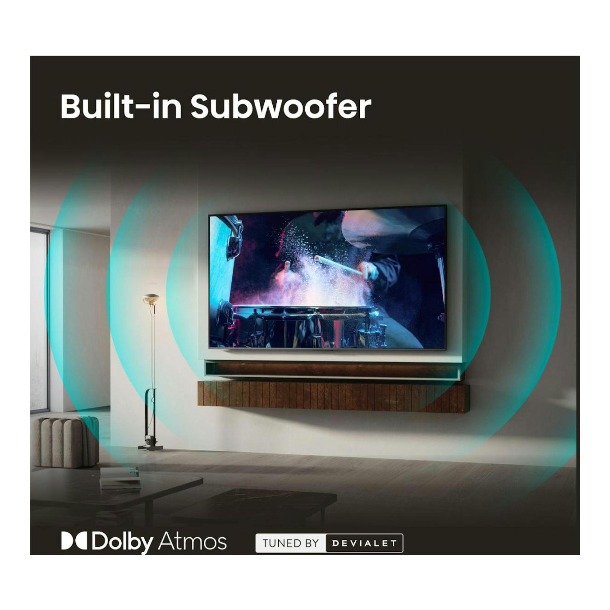 Hisense 85E8S: TV 4K Mini LED negro, vista frontal en pared de salón, con texto “Built-in Subwoofer”.
